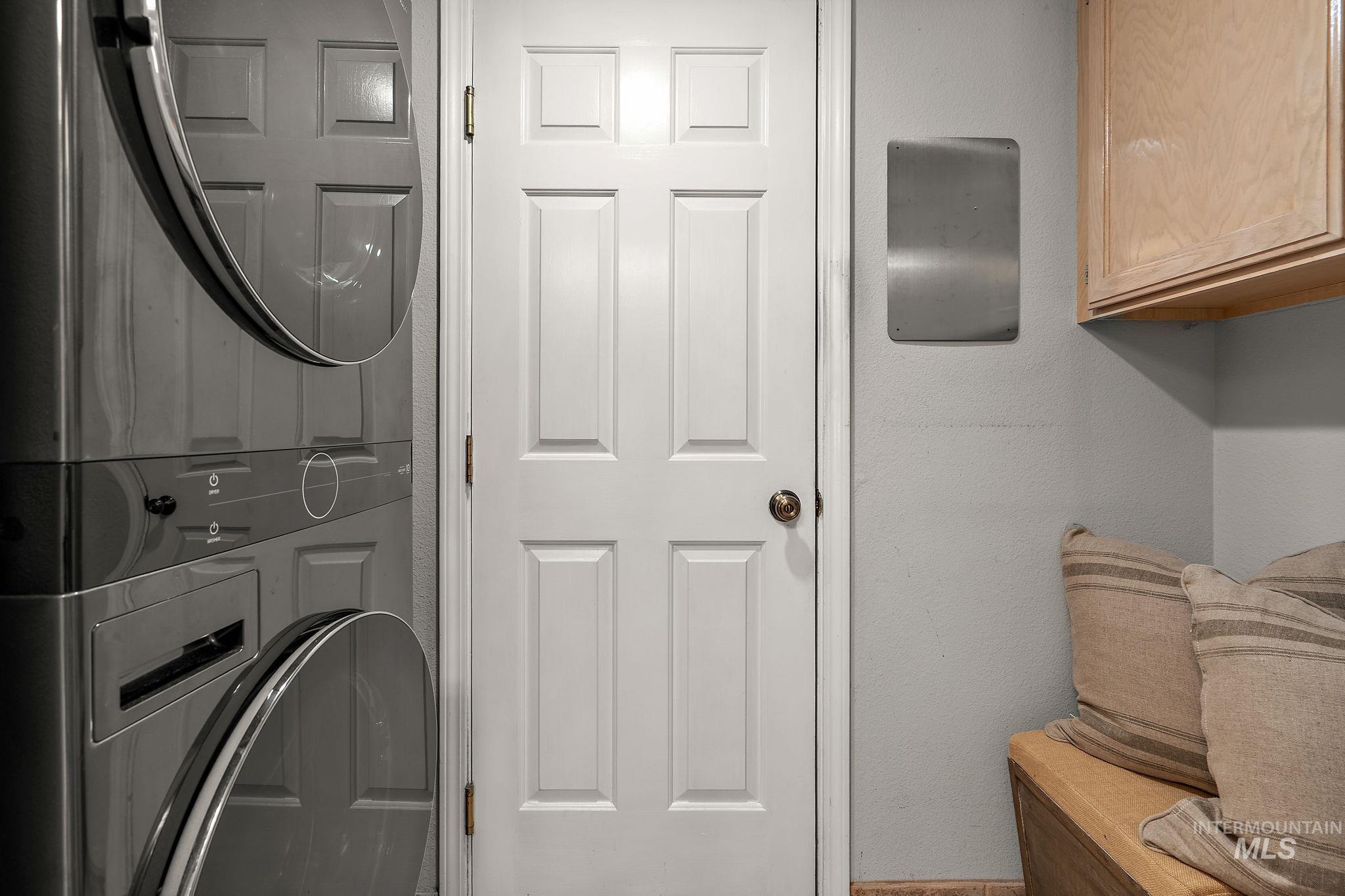 Laundry room with cabinet space and stacked washer and clothes dryer