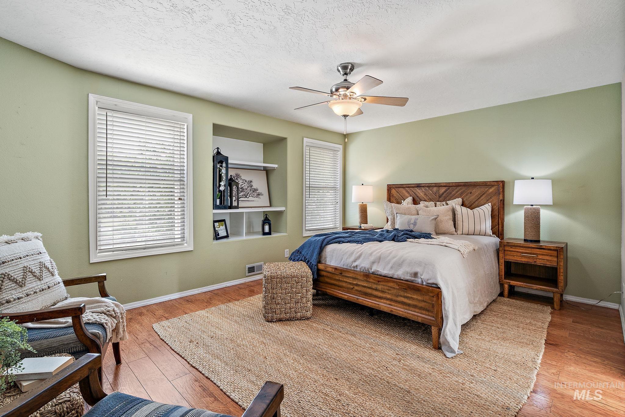Bedroom featuring light wood-type flooring, ceiling fan, and a textured ceiling