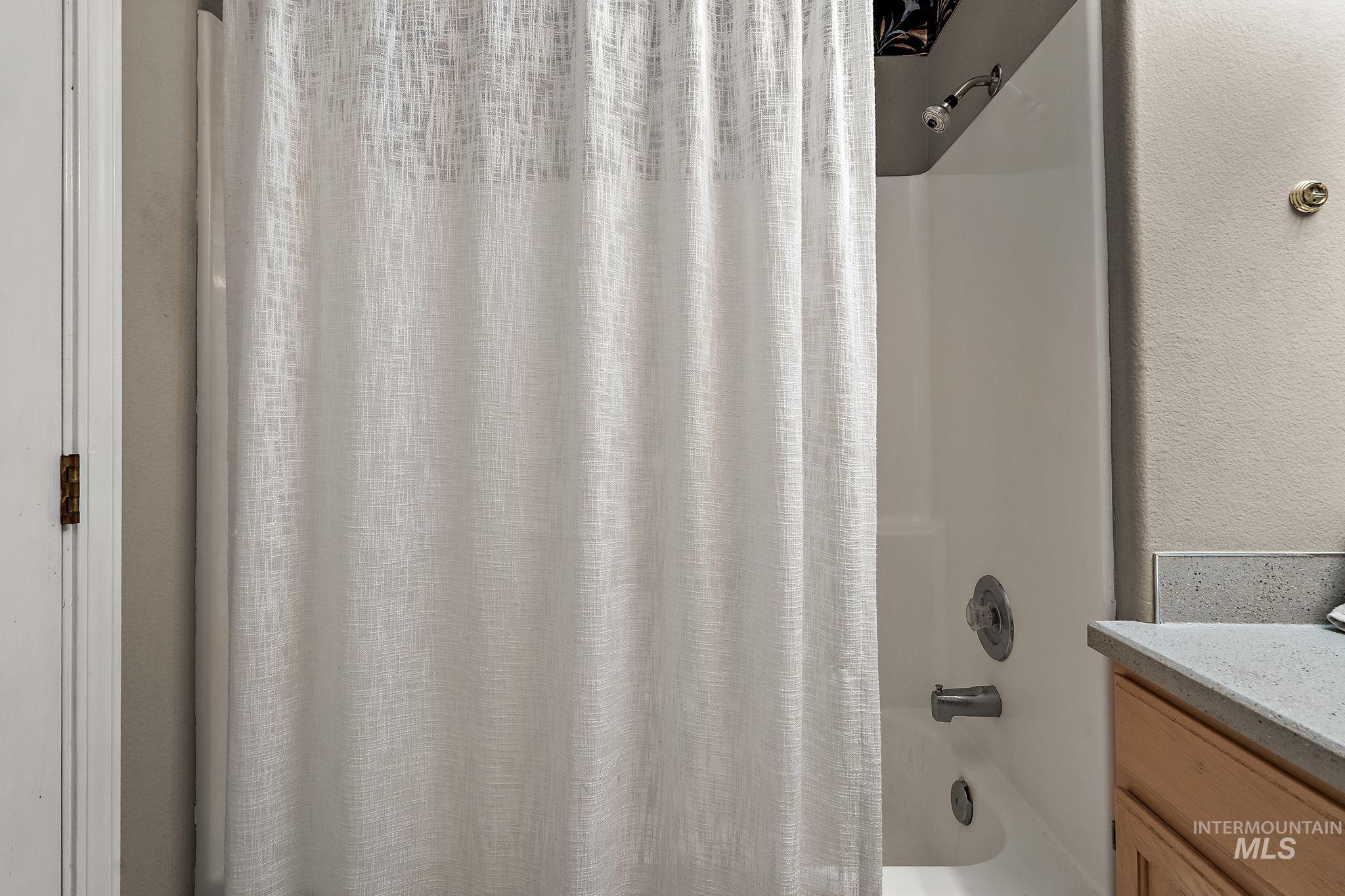 Bathroom featuring shower / bath combination with curtain and vanity