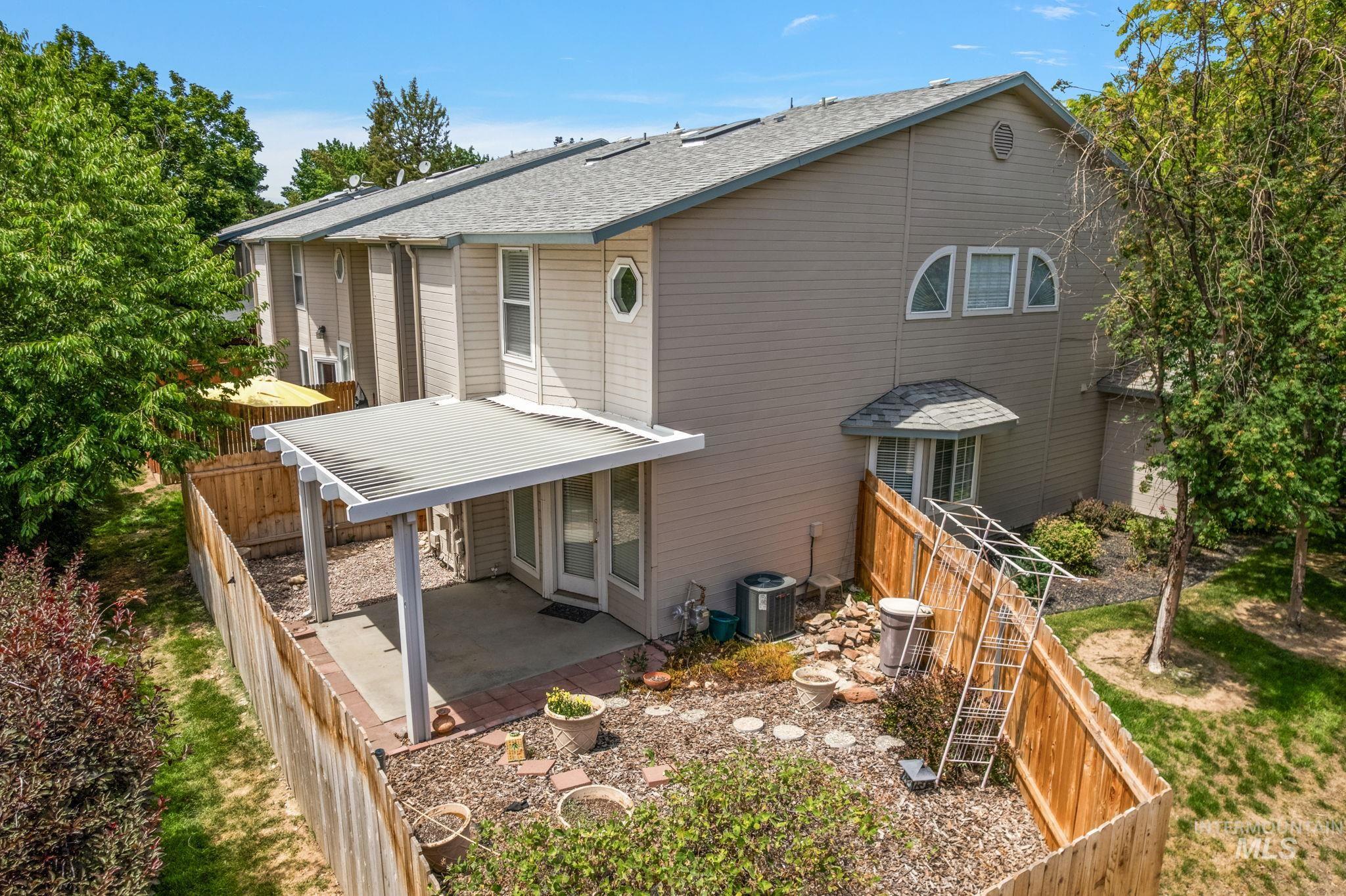 Back of house featuring a patio area, roof with shingles, and a fenced backyard