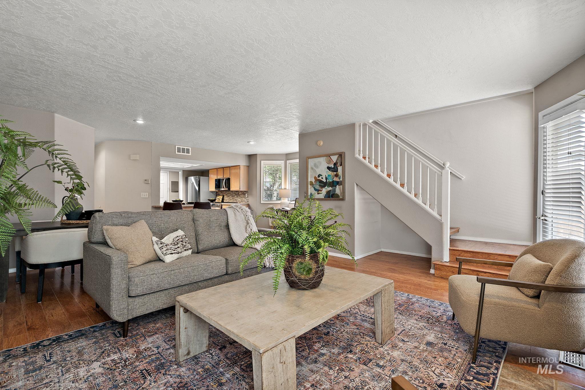 Living area featuring wood finished floors, stairway, and a textured ceiling