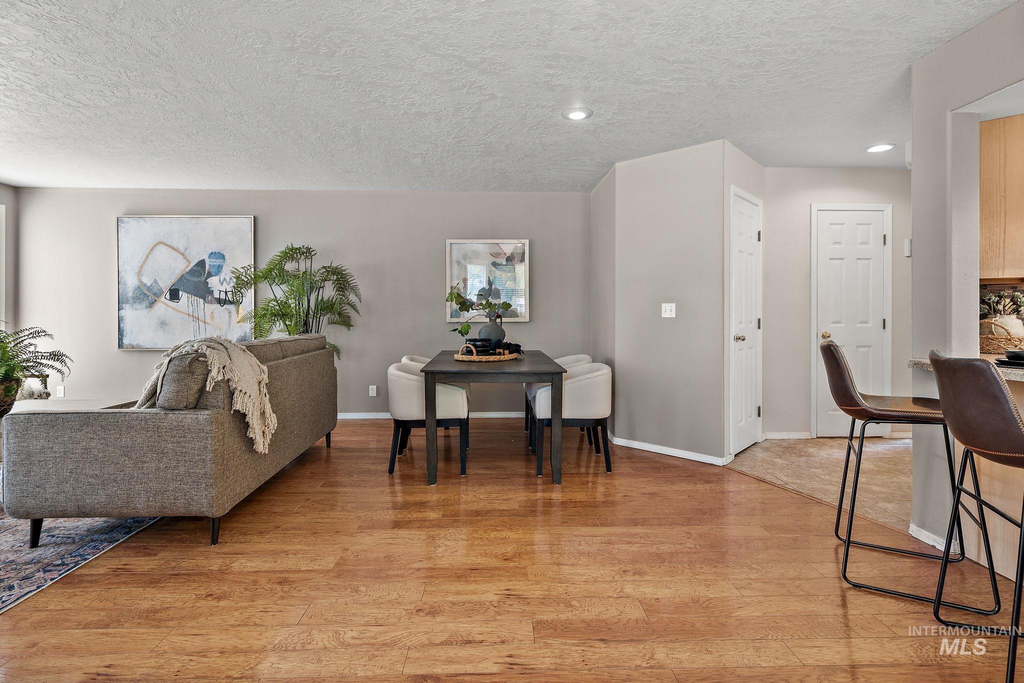 Living room with light wood finished floors, a textured ceiling, and recessed lighting