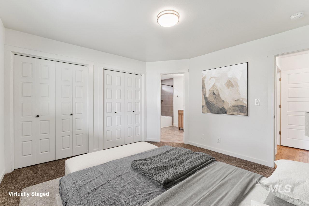 Bedroom with carpet, two closets, and connected bathroom