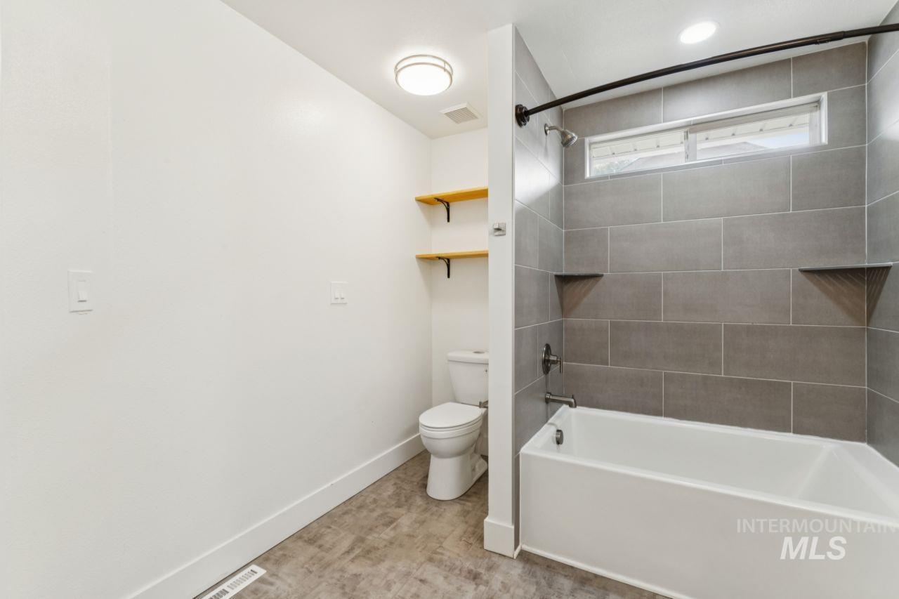 Full bath featuring bathtub / shower combination and toilet