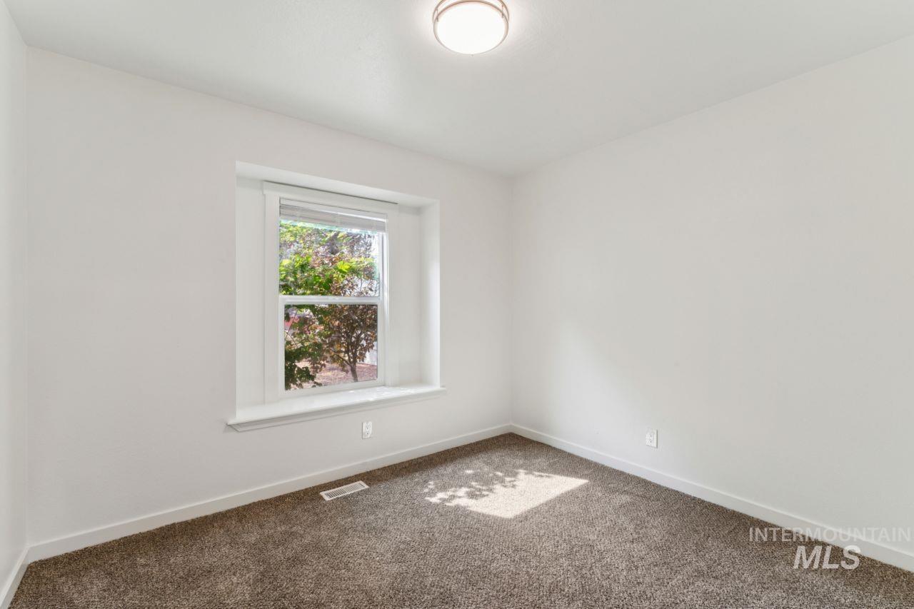 Carpeted empty room with baseboards