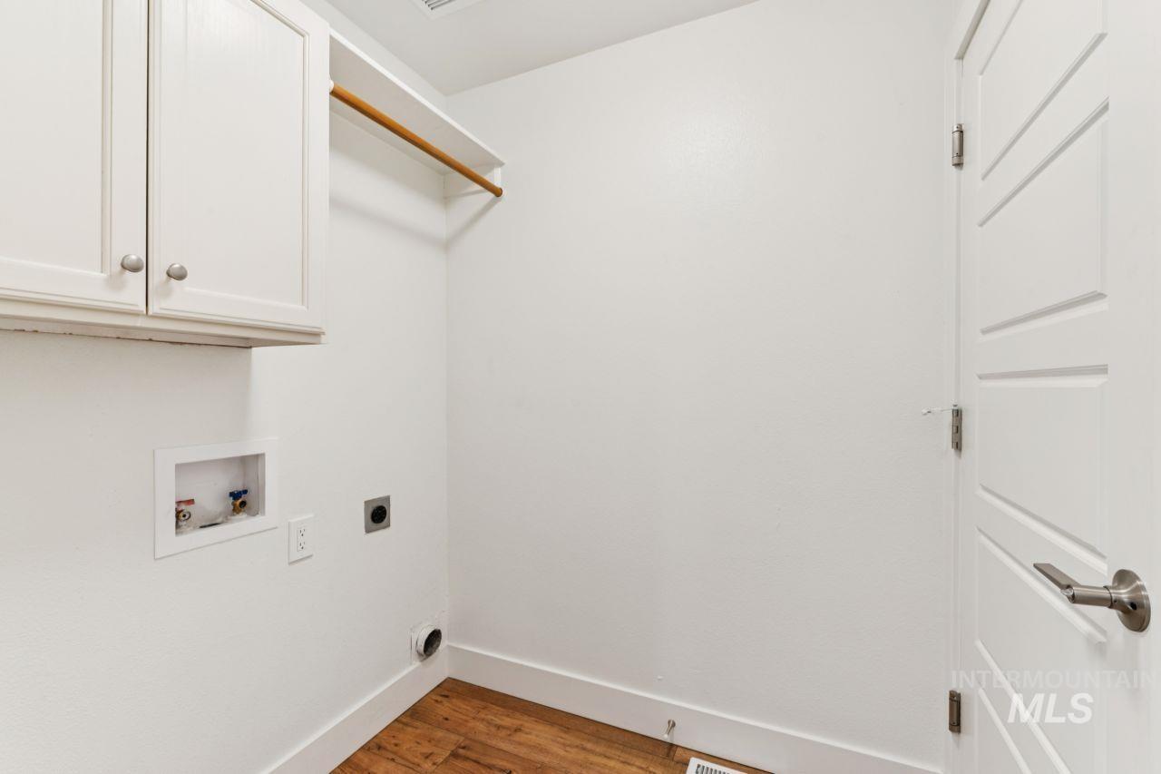 Laundry room with dark wood-style flooring, washer hookup, hookup for an electric dryer, and cabinet space