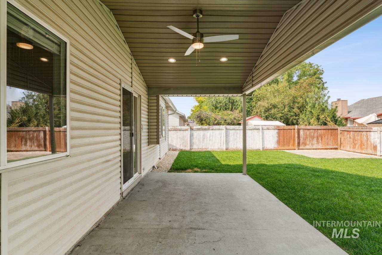Fenced backyard featuring a patio area and a ceiling fan