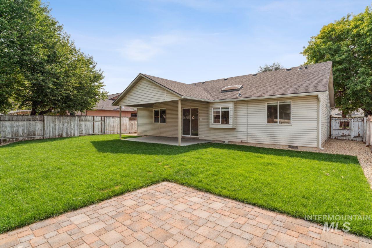 Back of property with a patio, a fenced backyard, and a shingled roof