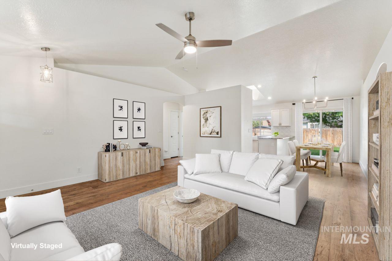 Living area featuring wood finished floors, arched walkways, lofted ceiling, and a ceiling fan
