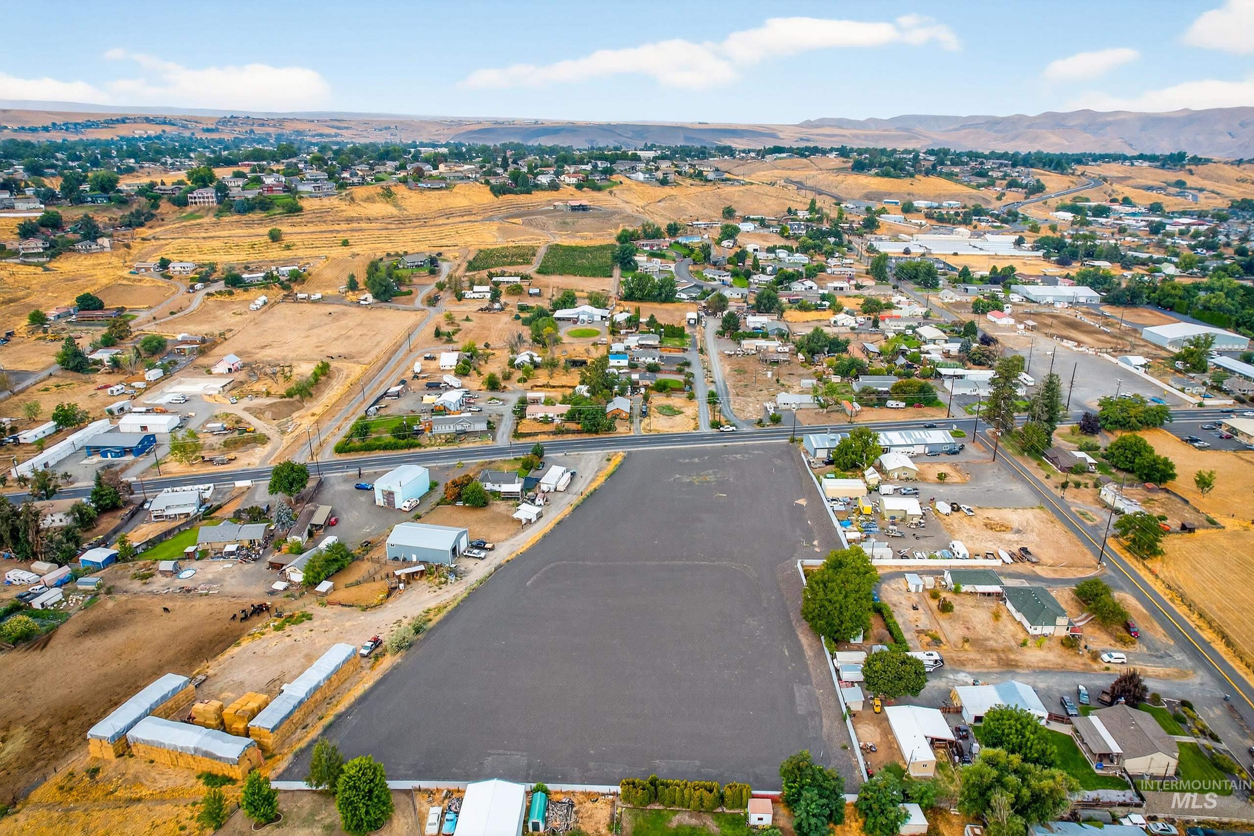 Aerial view of property and surrounding area featuring a mountain backdrop