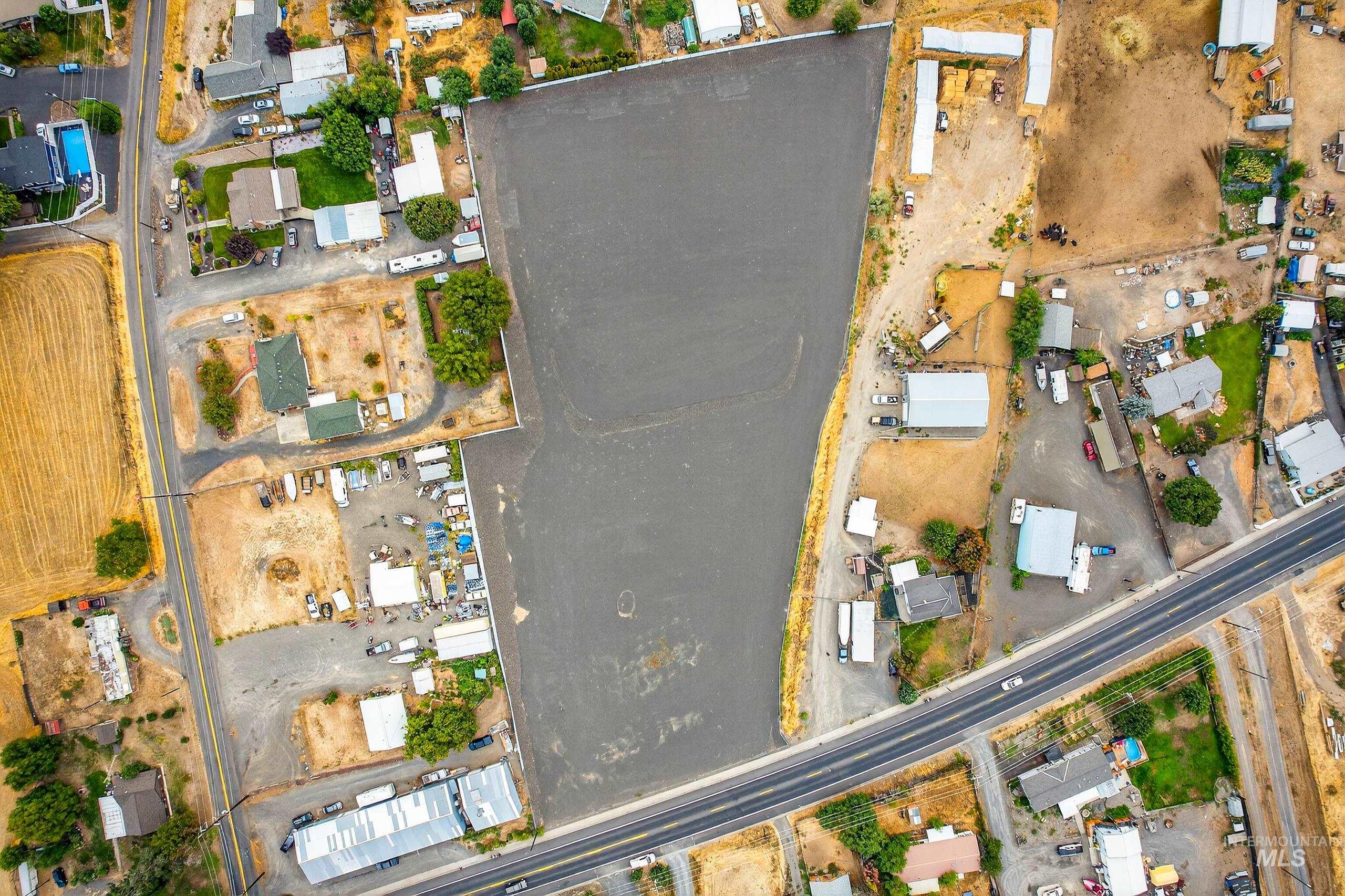 Aerial view of property and surrounding area with nearby suburban area