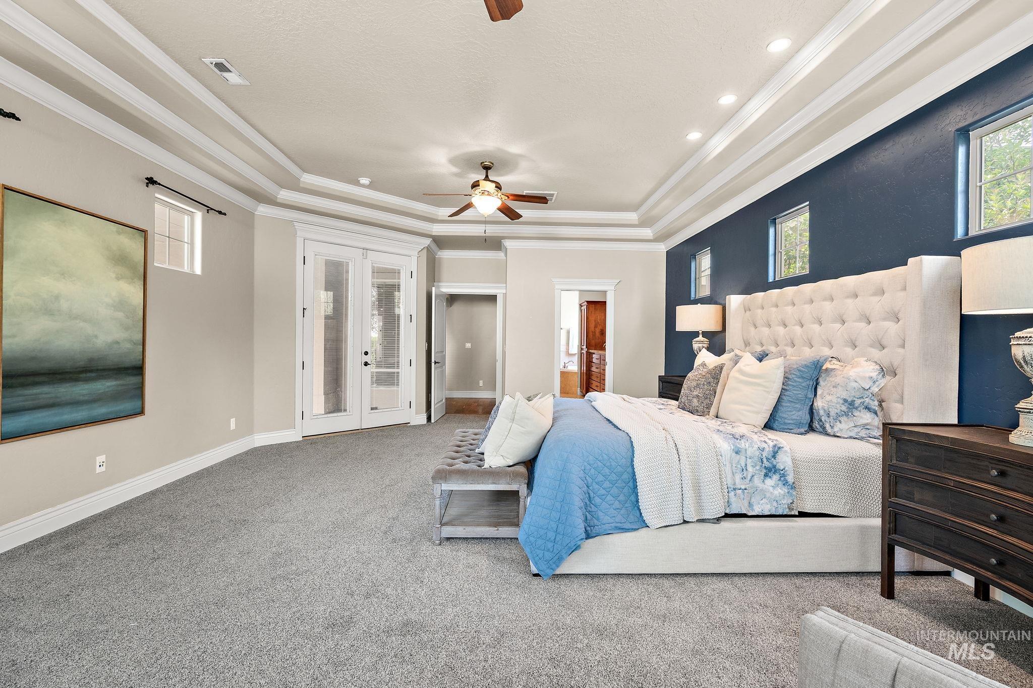 Bedroom with french doors, a tray ceiling, carpet flooring, access to exterior, and ensuite bath