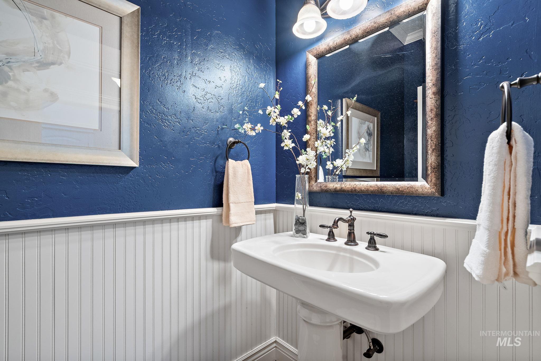 Bathroom with a textured wall and a wainscoted wall