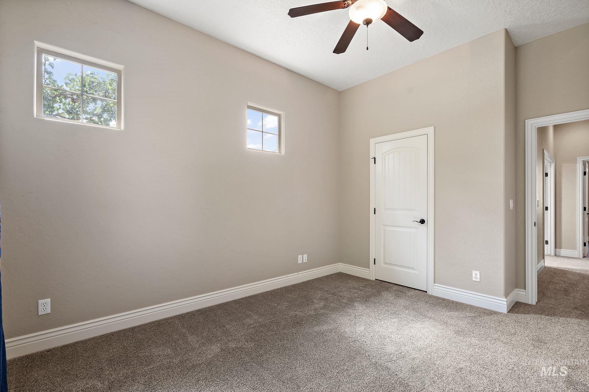 Unfurnished bedroom featuring carpet, a ceiling fan, and a textured ceiling