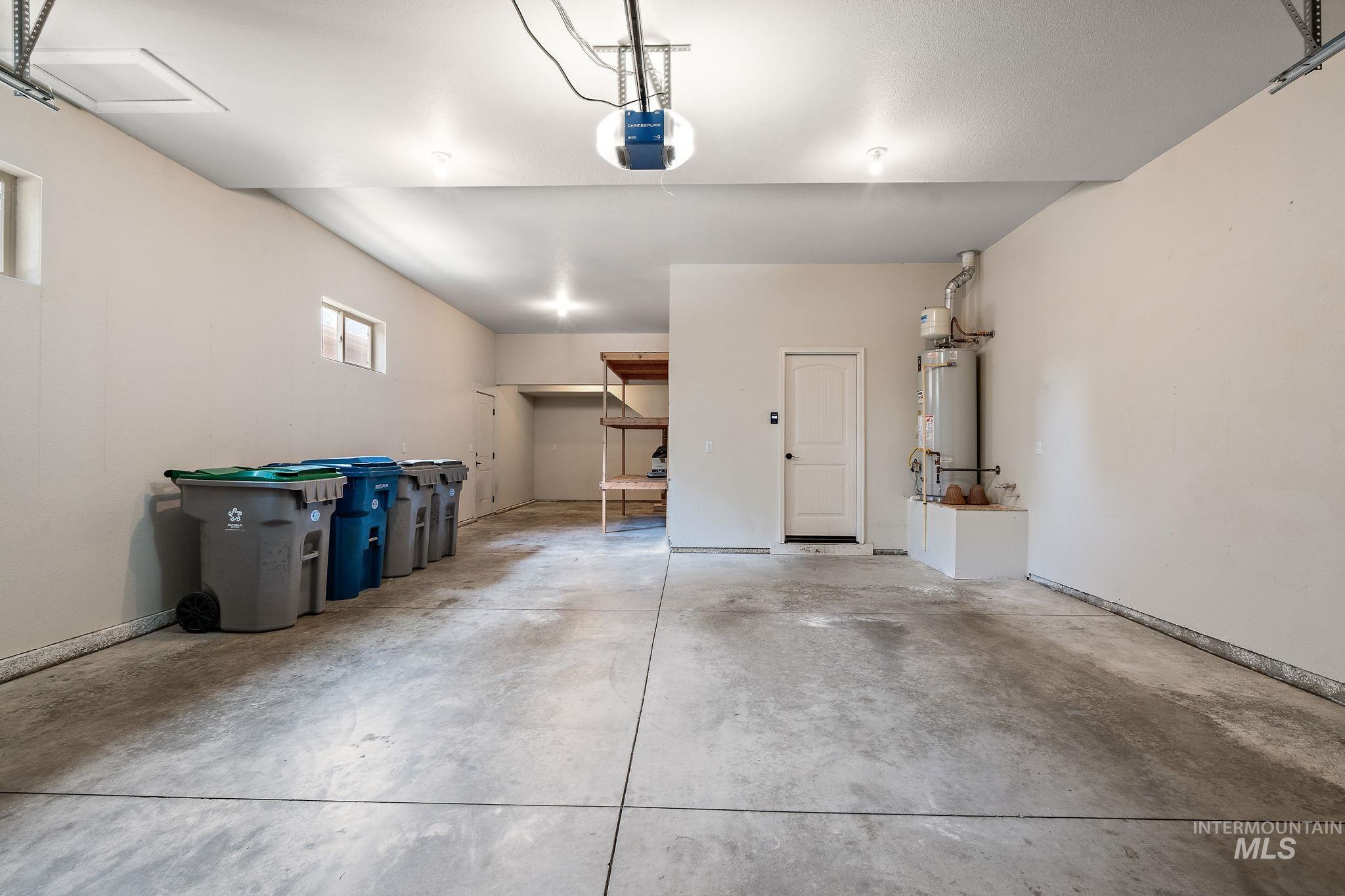 Garage featuring water heater and a garage door opener