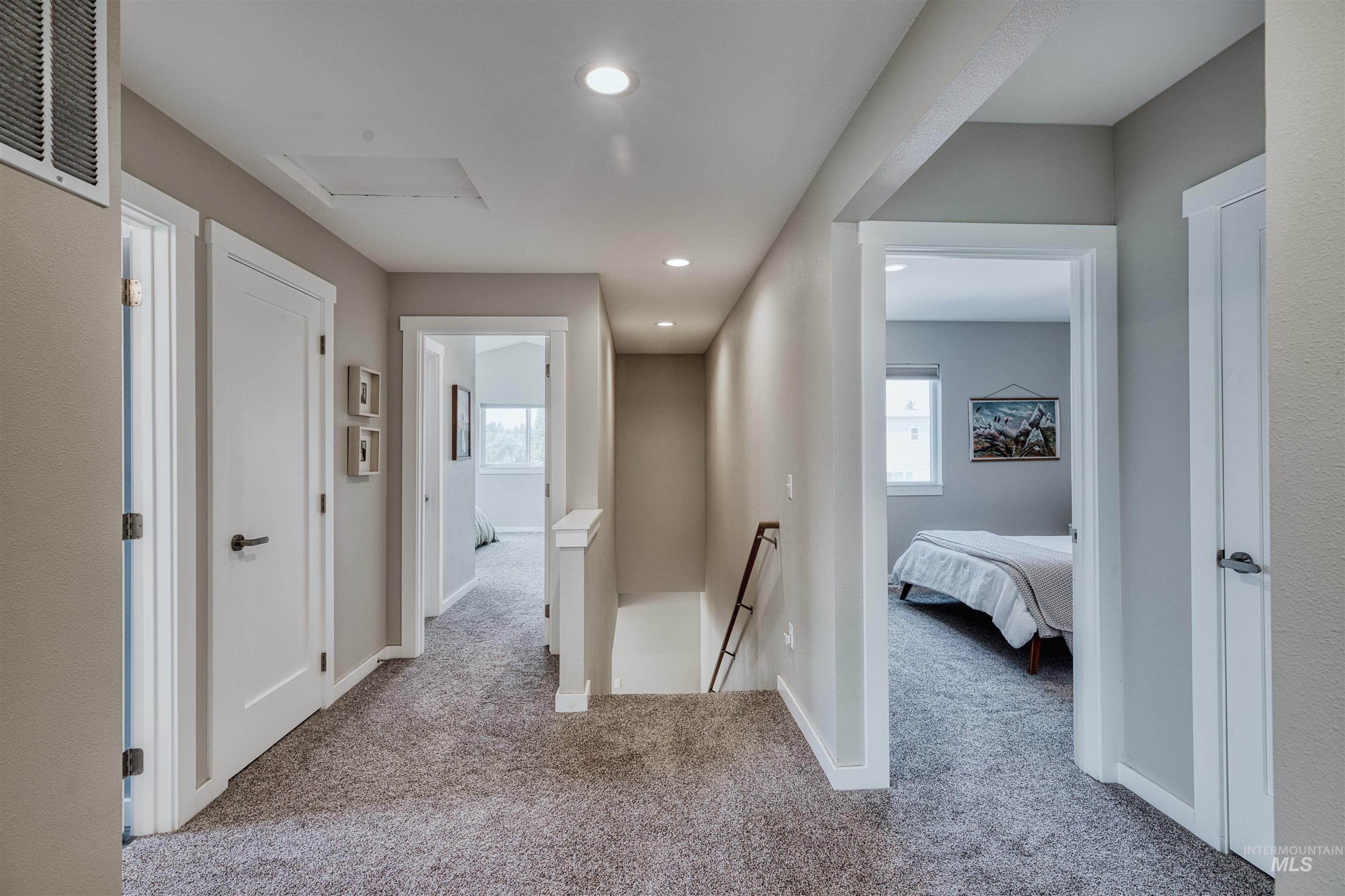 Hallway featuring carpet, an upstairs landing, plenty of natural light, and recessed lighting
