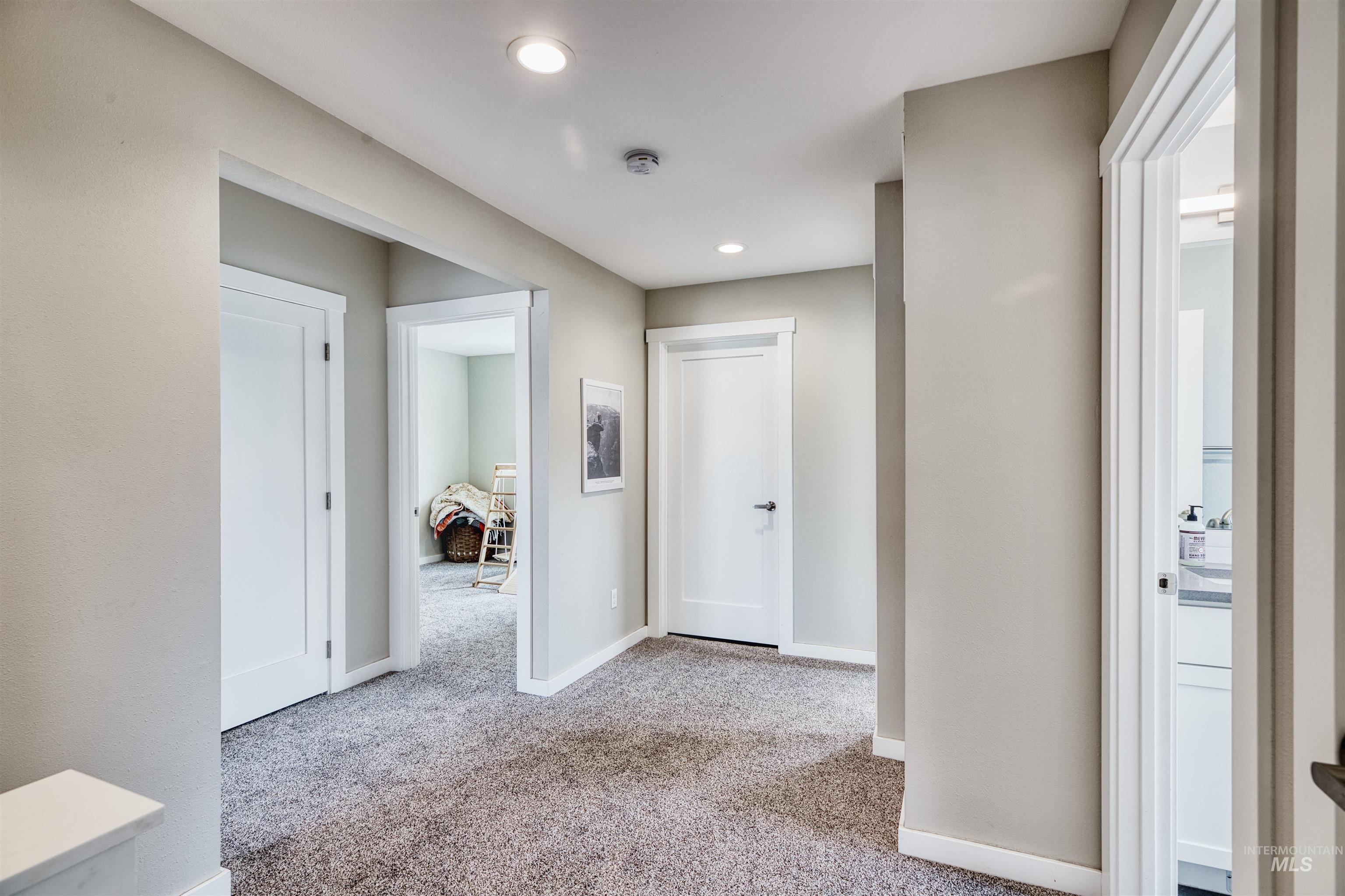 Hall with light carpet and recessed lighting