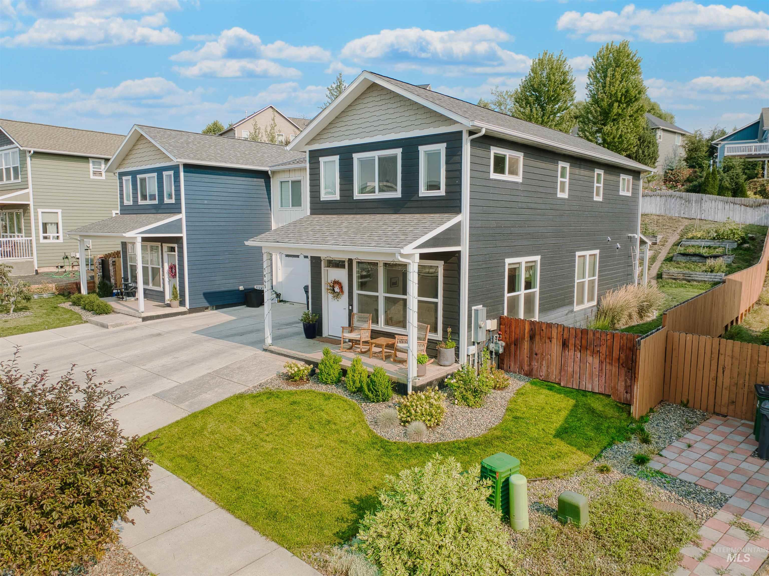 Traditional home with covered porch, a shingled roof, and concrete driveway