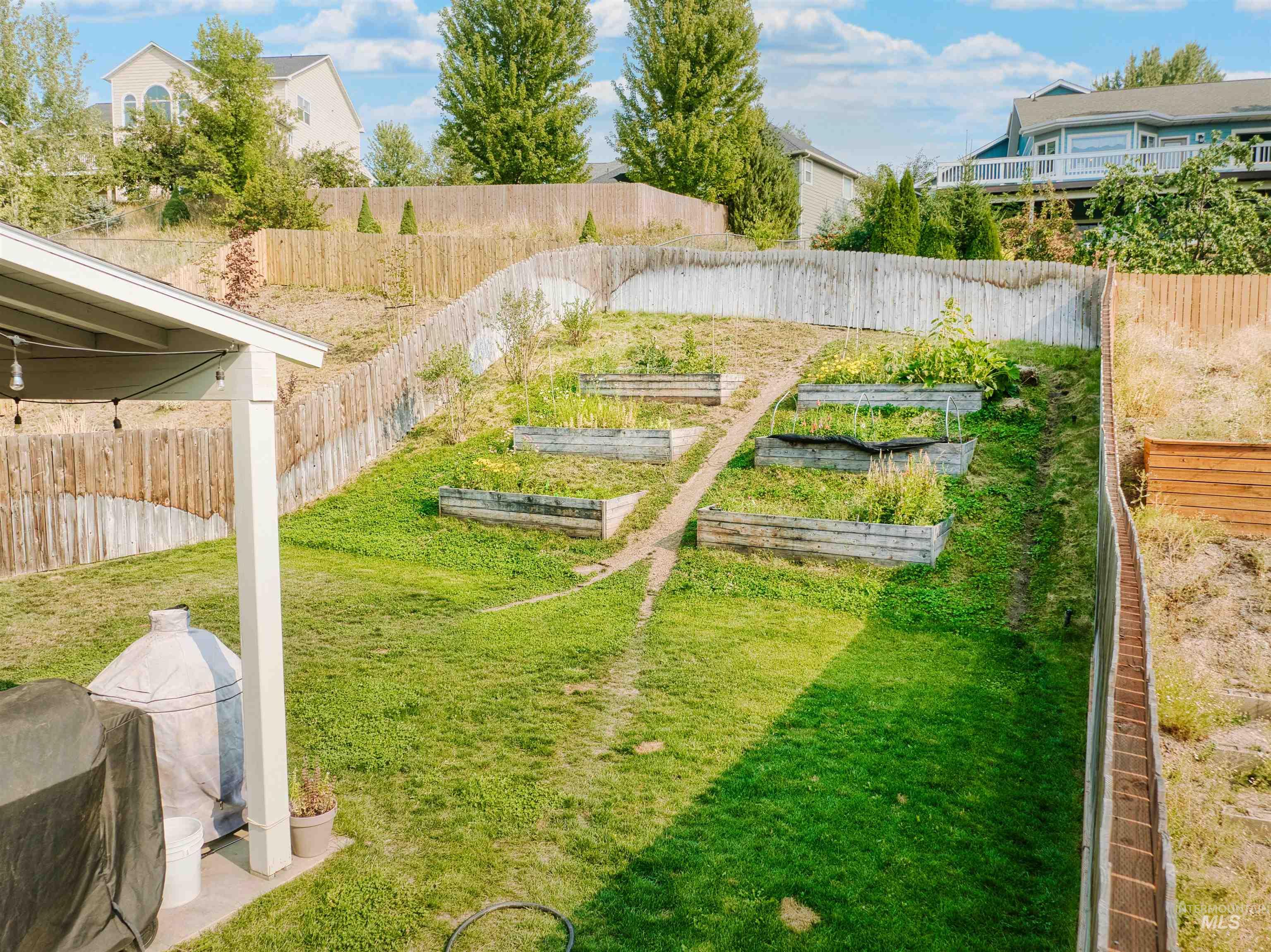 Fenced backyard featuring a vegetable garden