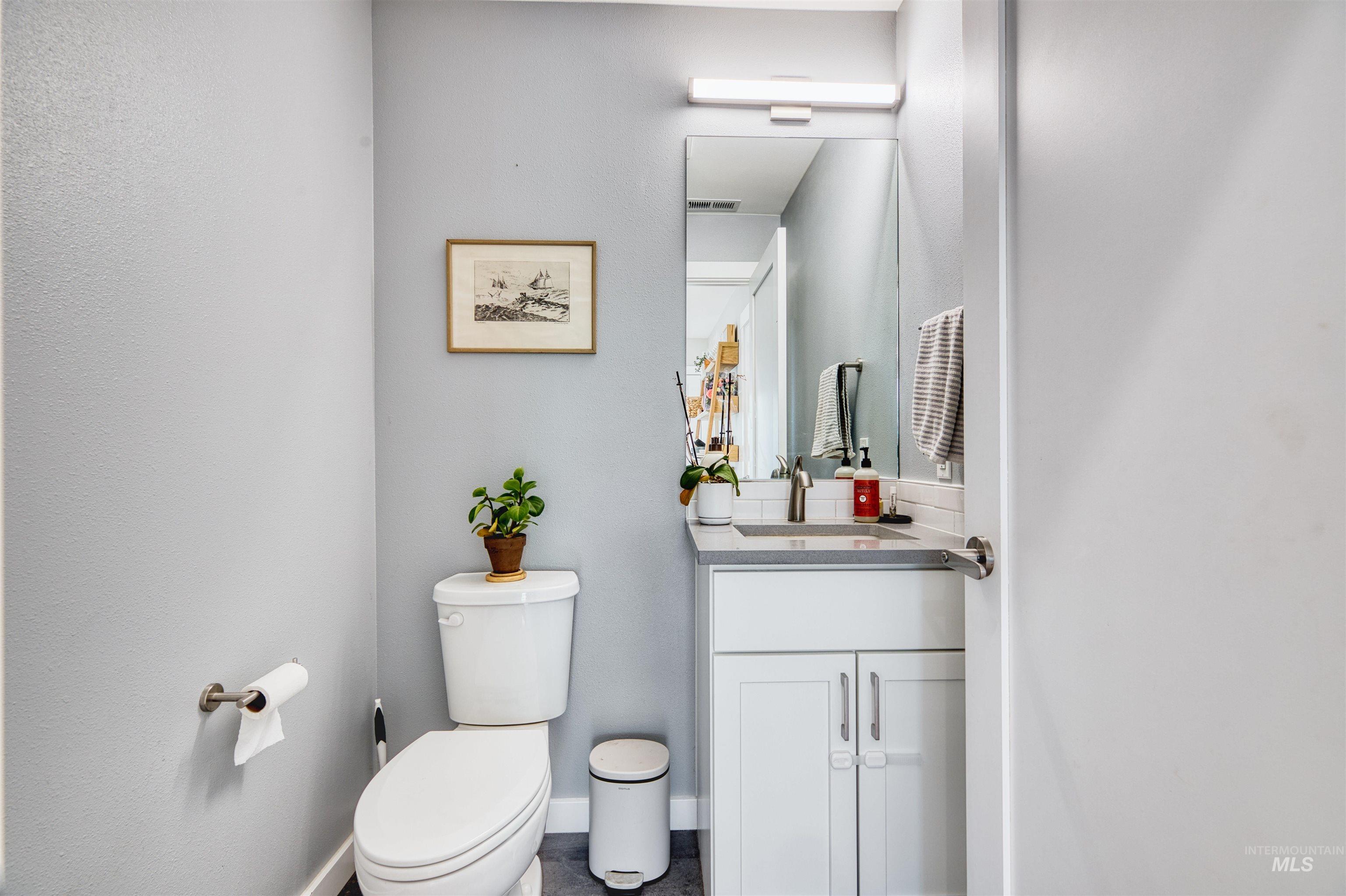 Half bathroom with vanity and toilet