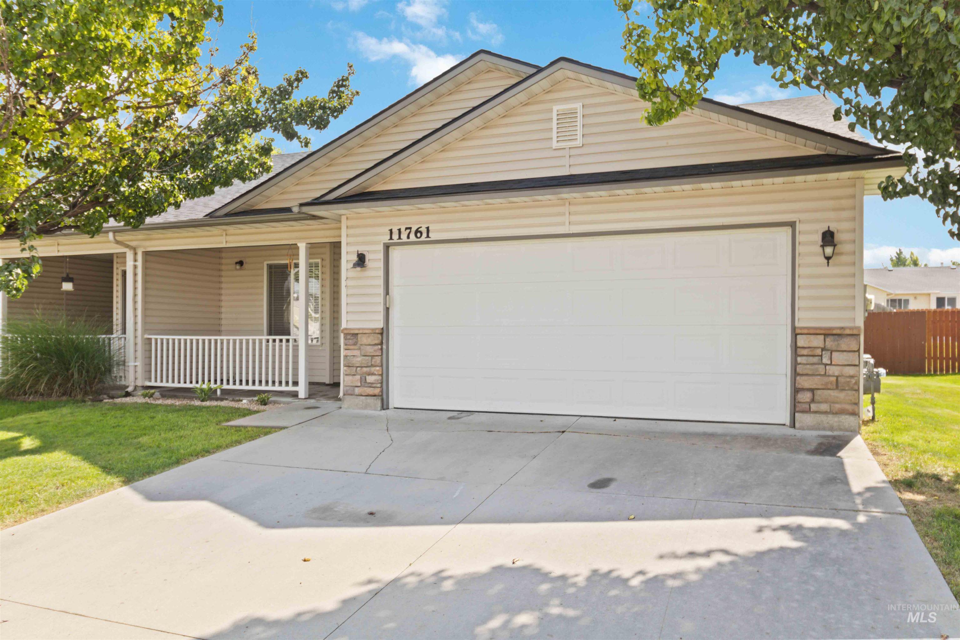 Ranch-style home with stone siding, a porch, driveway, and an attached garage