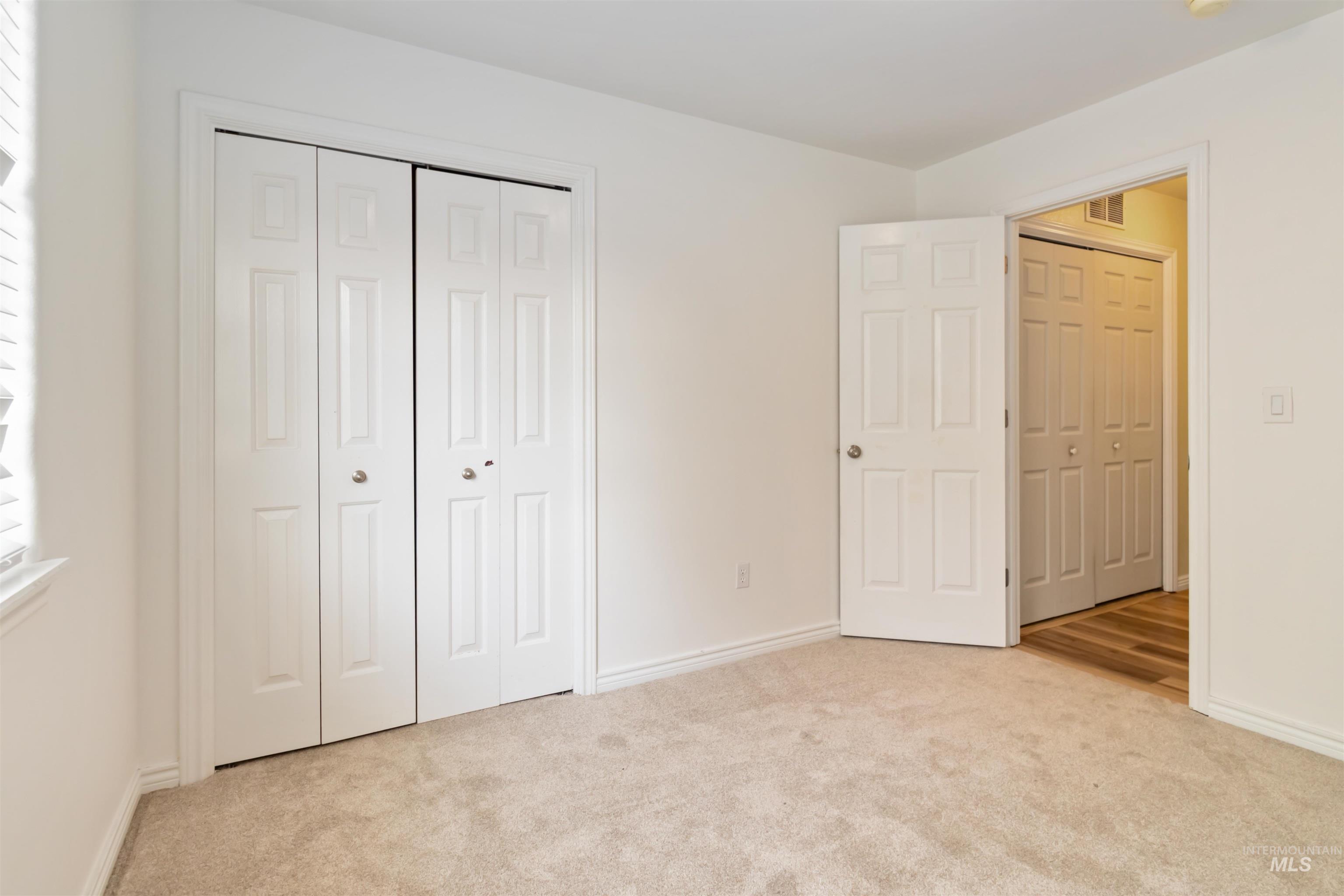Unfurnished bedroom featuring light colored carpet and a closet