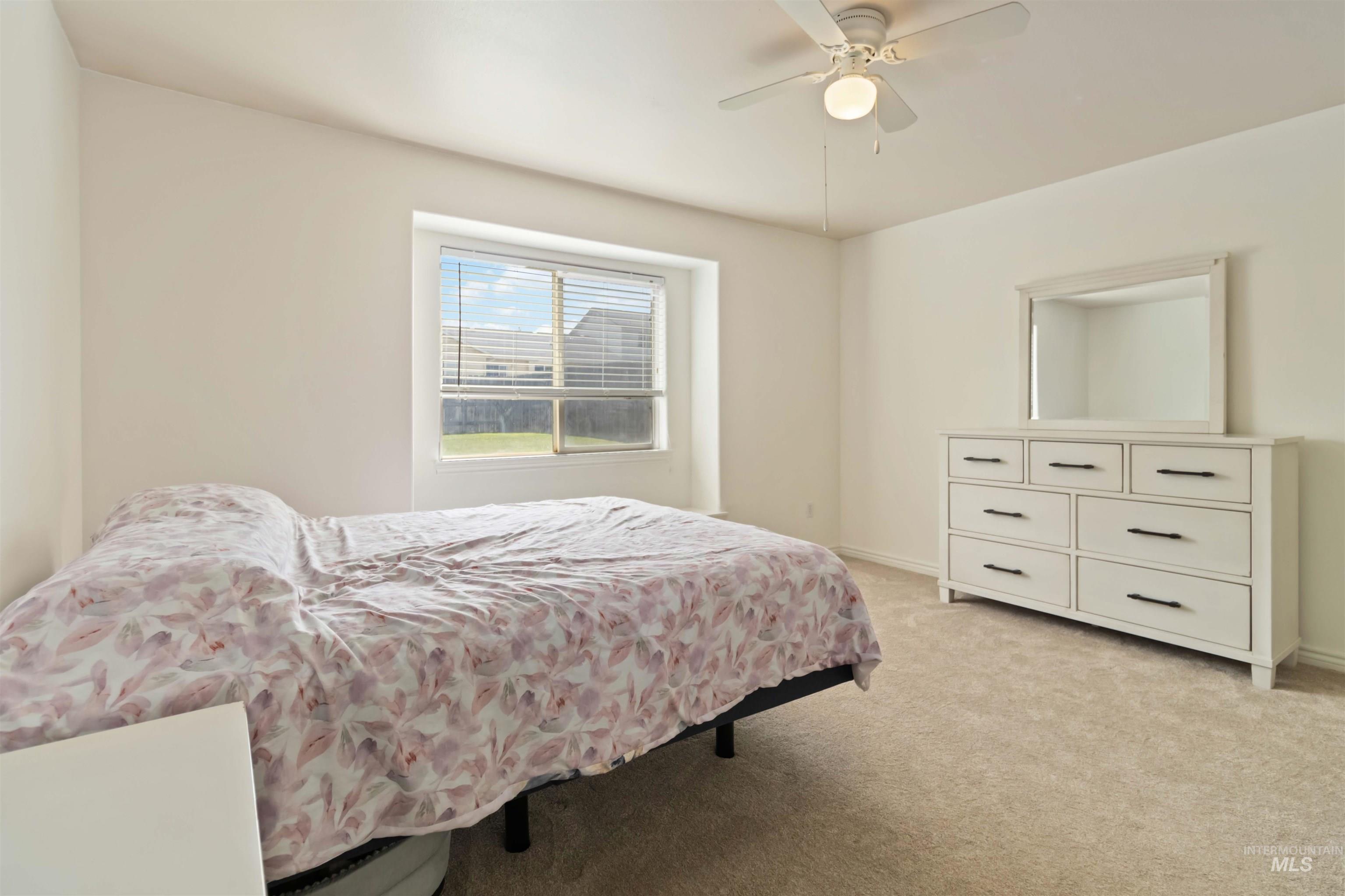 Bedroom featuring light colored carpet and a ceiling fan