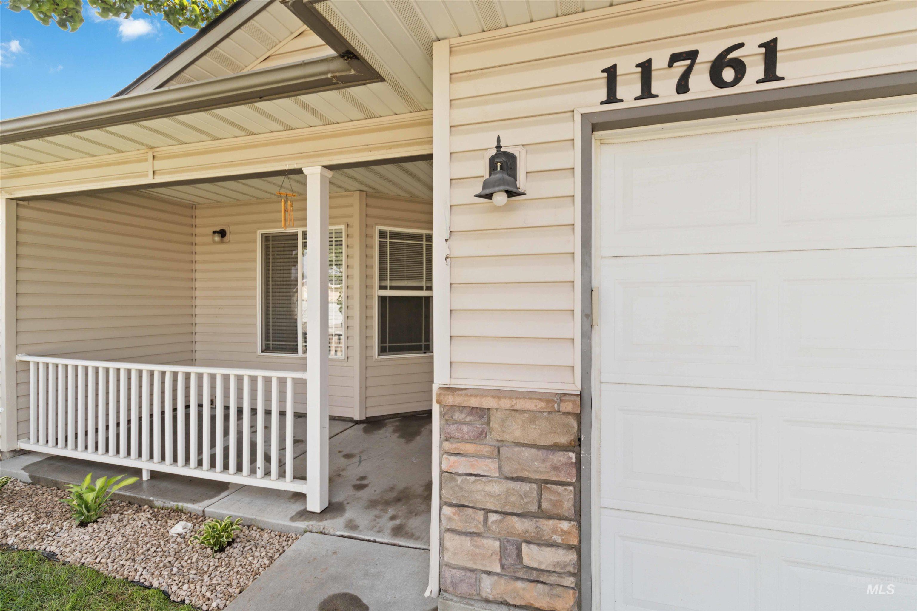 Entrance to property featuring covered porch and a garage