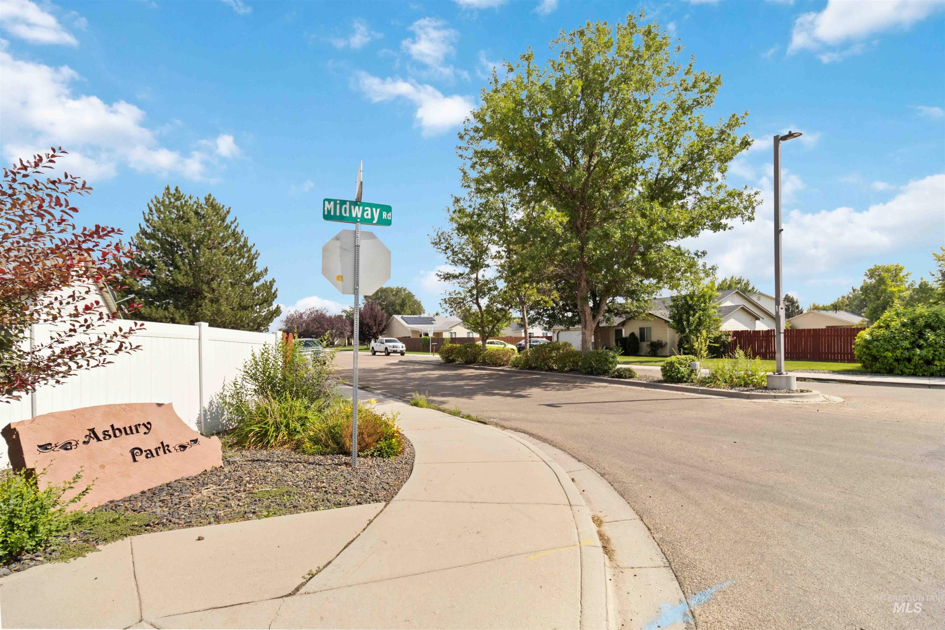 View of asphalt street with sidewalks, curbs, street lights, traffic signs, and a residential view