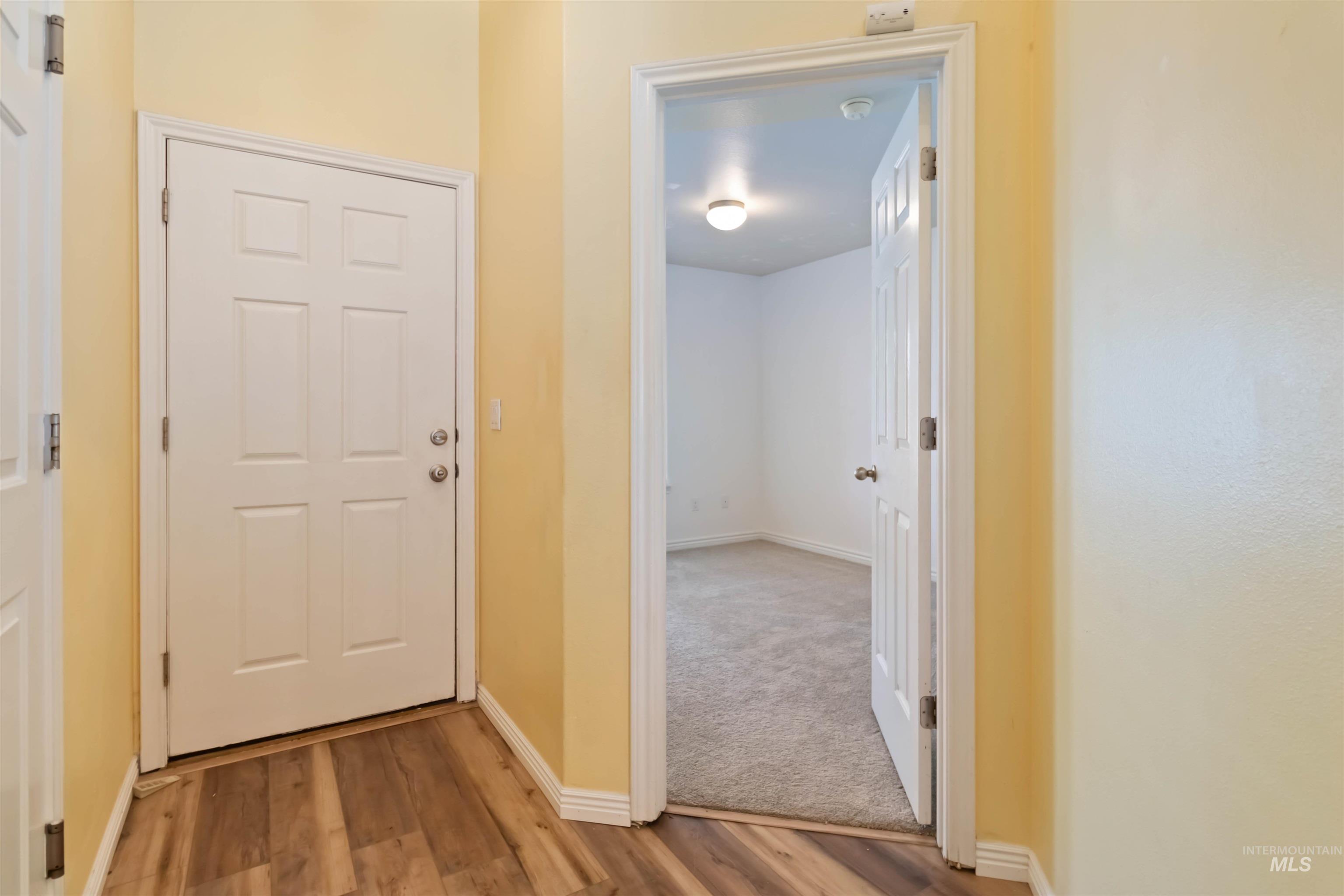 Corridor featuring baseboards and wood finished floors