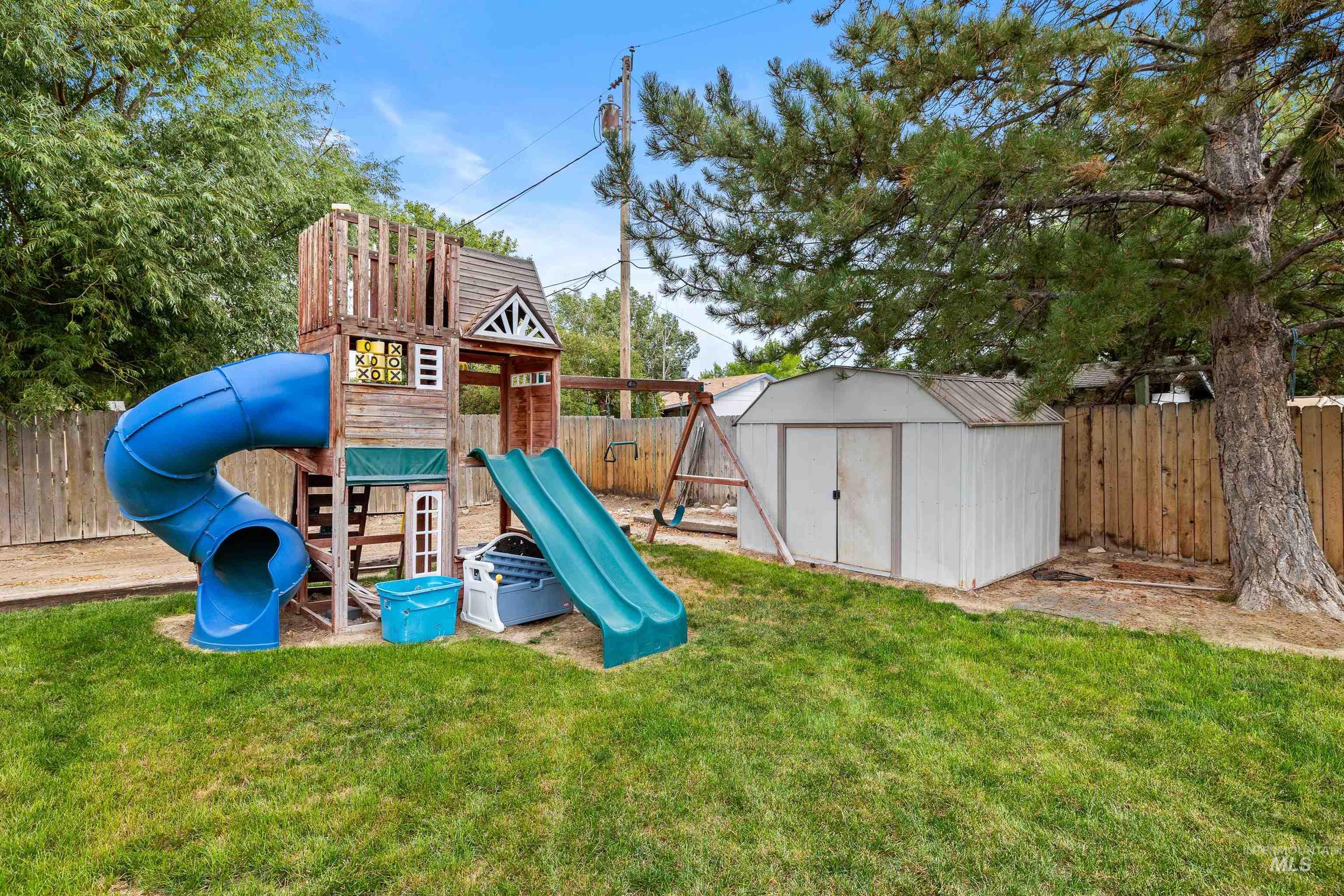 View of play area featuring a fenced backyard and a shed