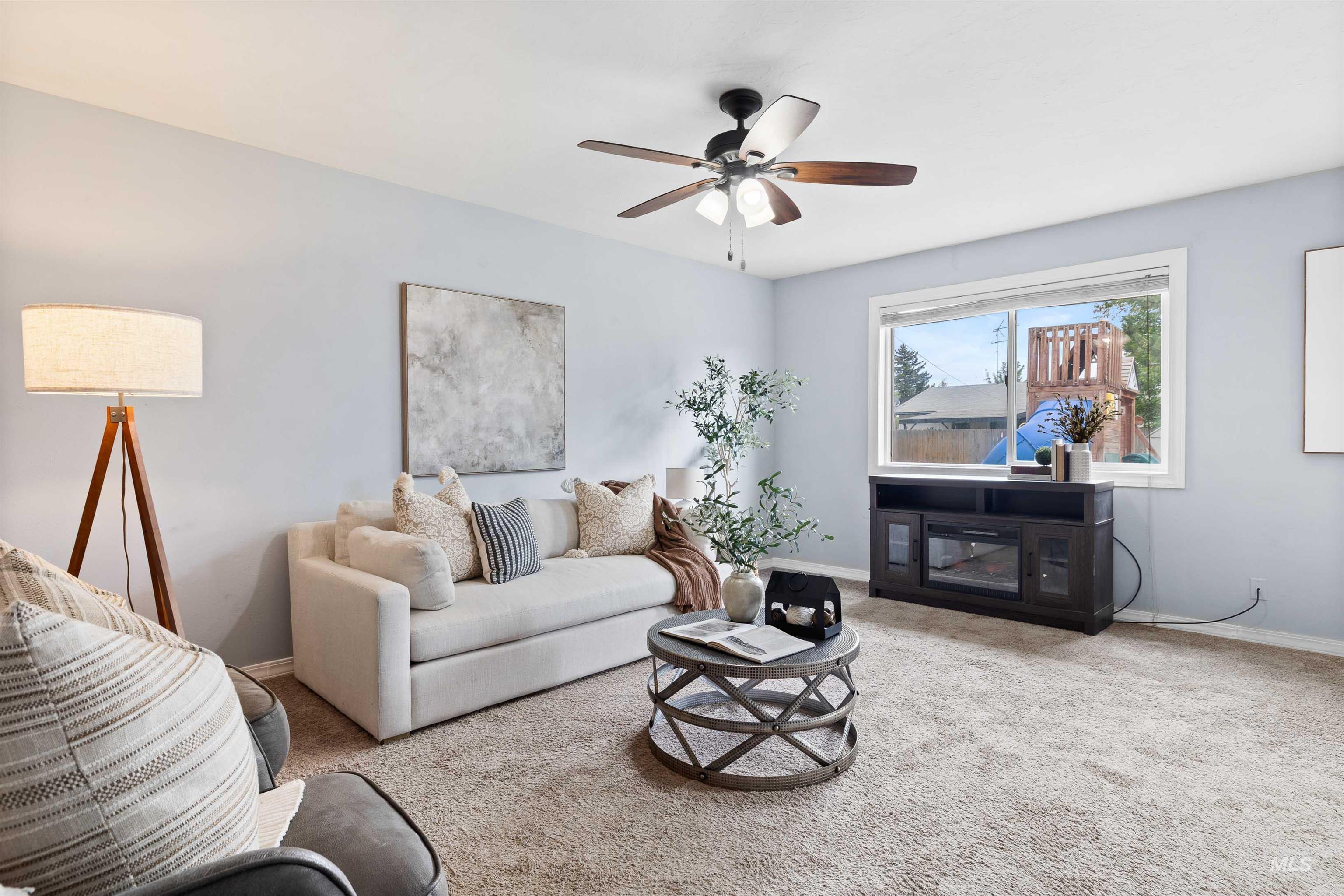 Living room with carpet flooring and ceiling fan