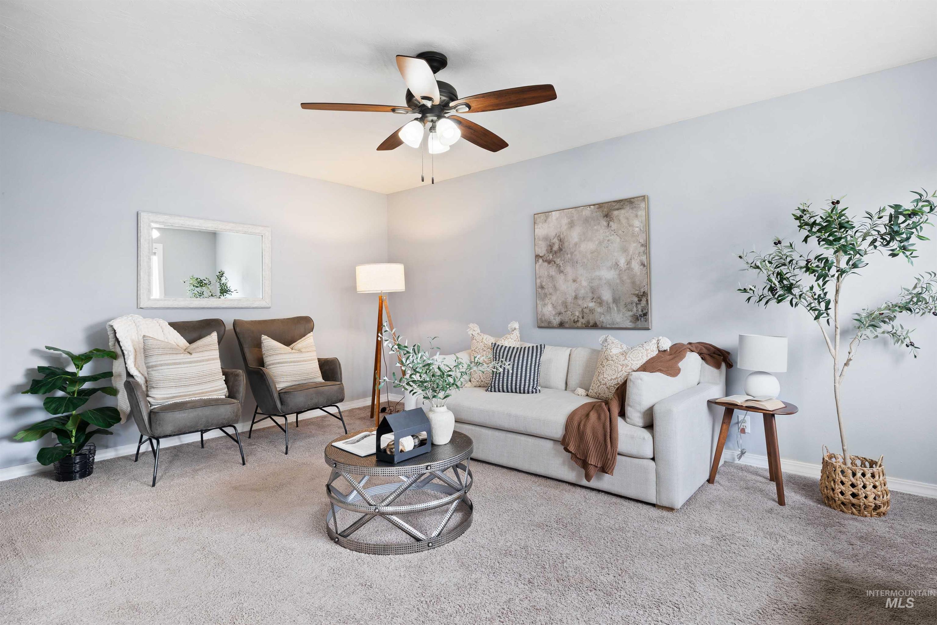 Carpeted living room featuring baseboards and ceiling fan
