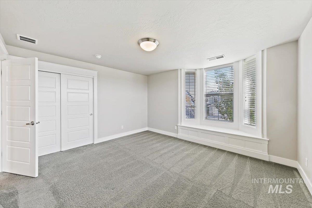 Unfurnished bedroom with carpet flooring, a textured ceiling, and a closet