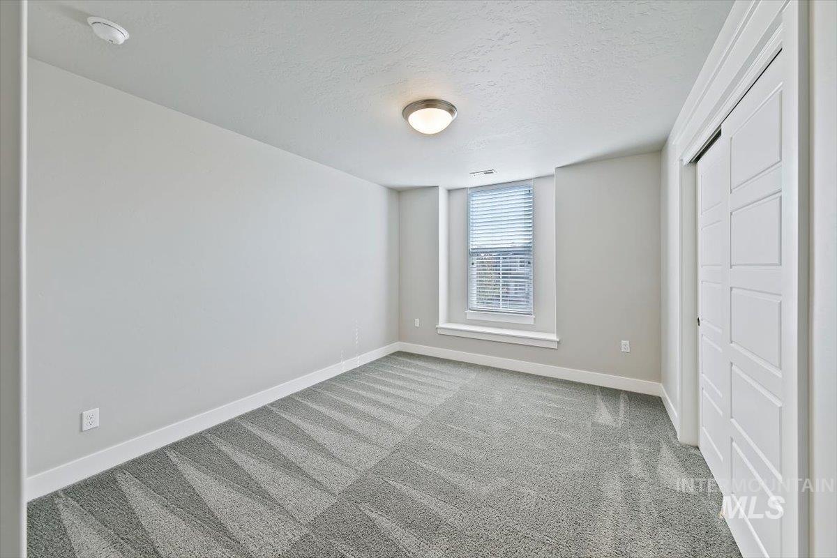Unfurnished bedroom with carpet floors and a textured ceiling