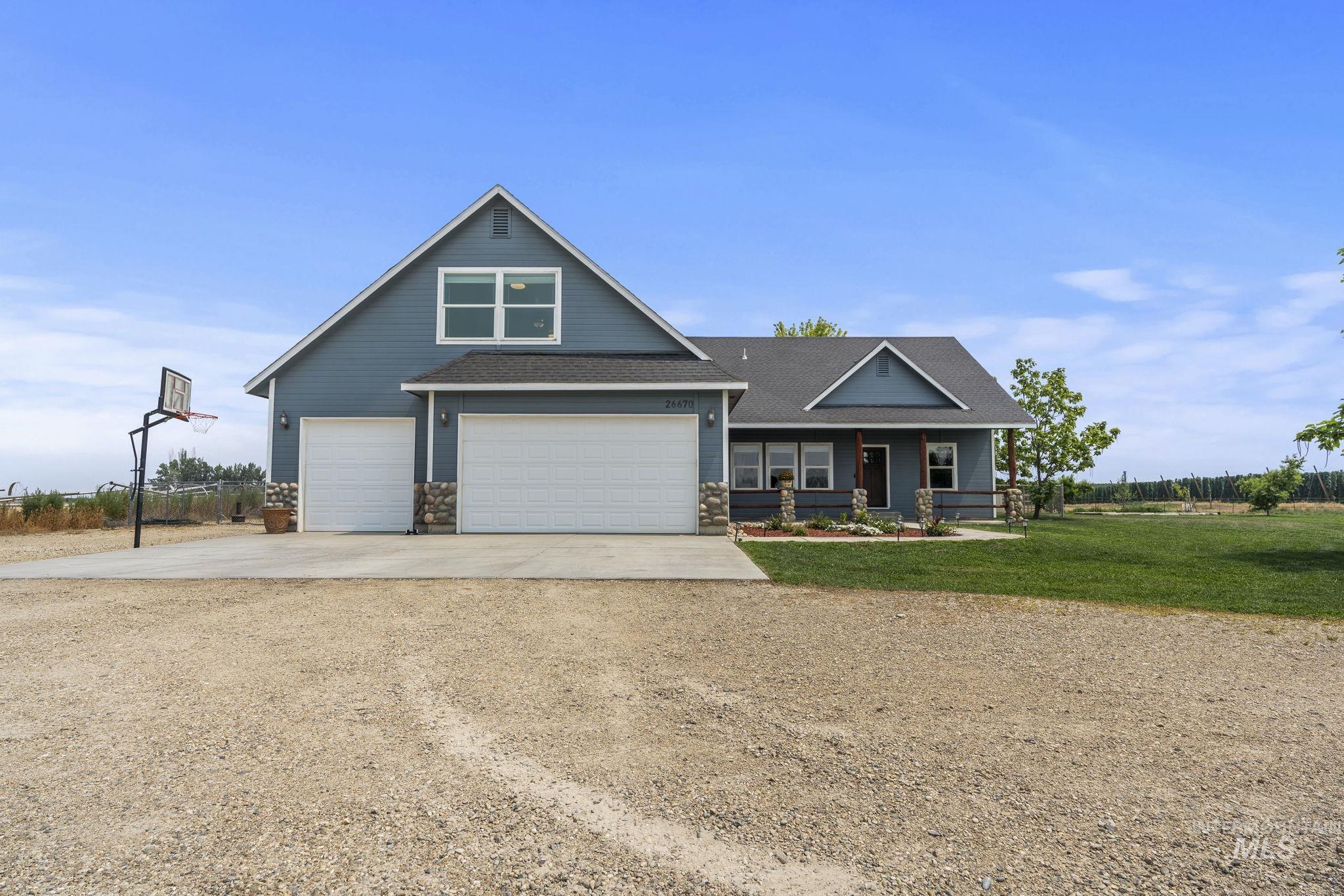 Craftsman-style house featuring driveway, covered porch, and roof with shingles