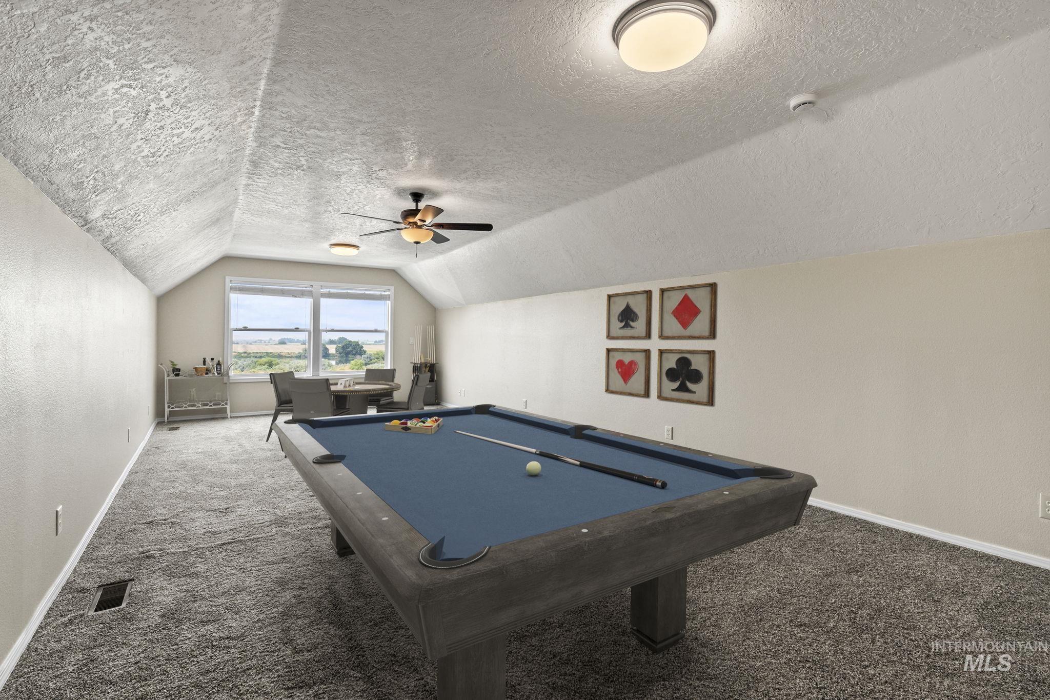 Playroom with carpet floors, vaulted ceiling, a textured ceiling, and pool table