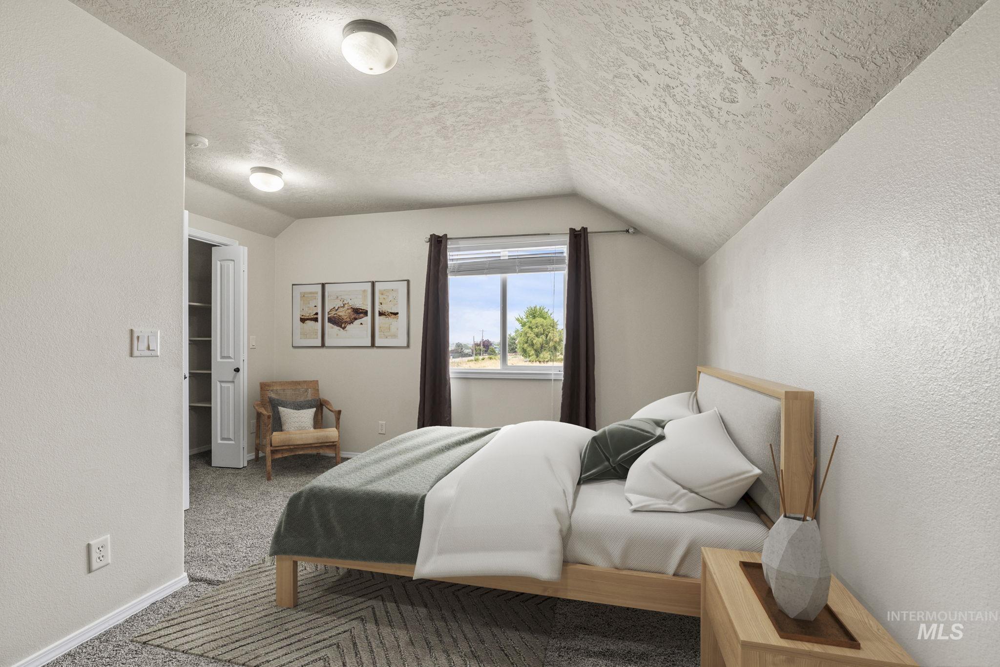 Bedroom featuring a textured wall, carpet flooring, lofted ceiling, and a textured ceiling