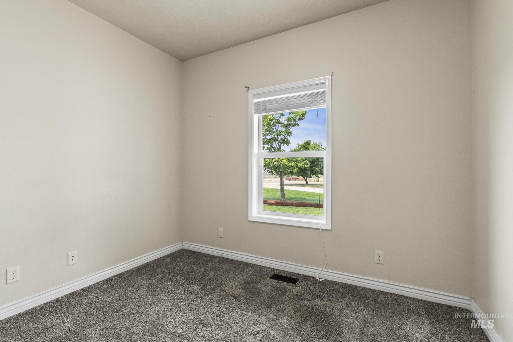 Carpeted spare room with baseboards