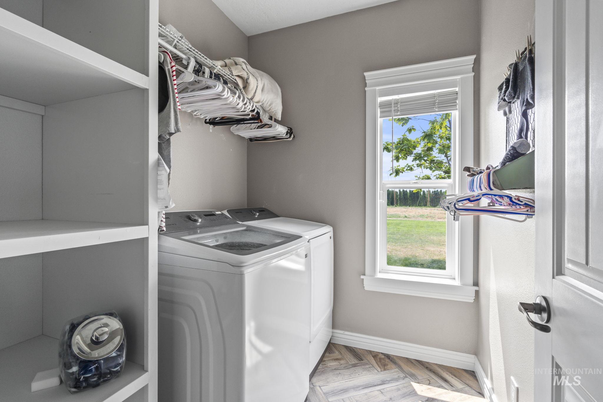 Laundry area with separate washer and dryer and baseboards