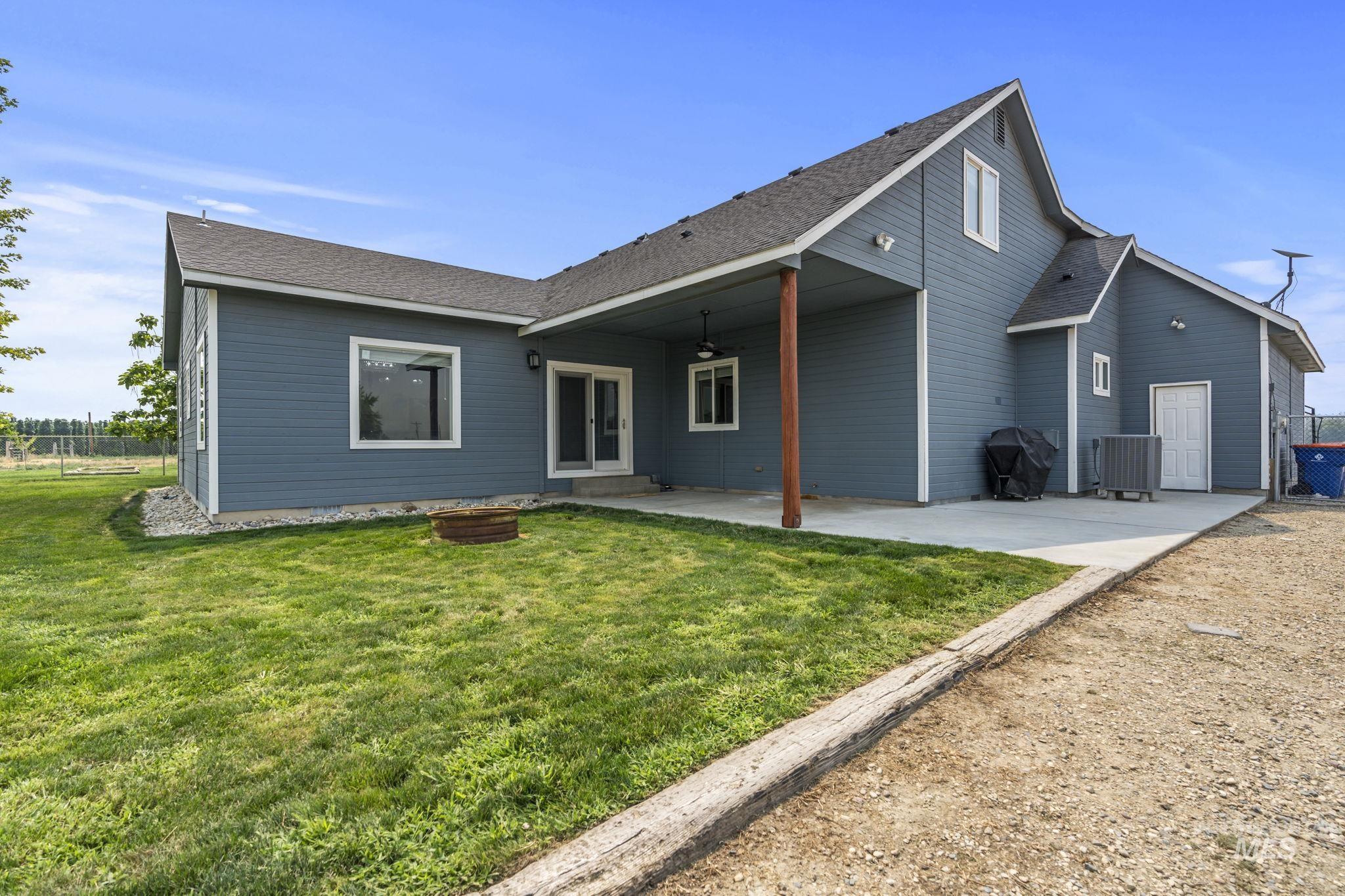 Back of house with a patio area and roof with shingles