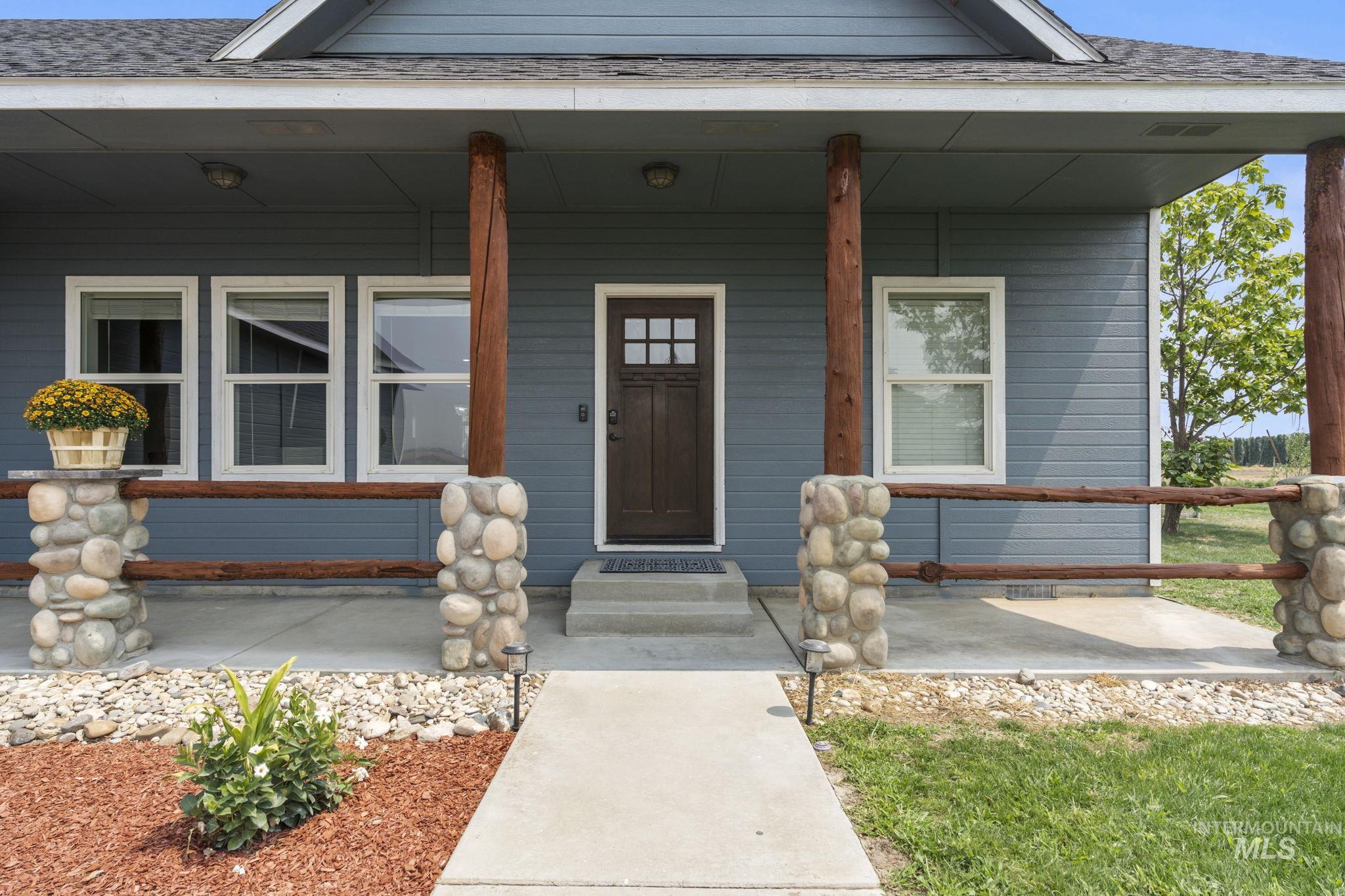 Doorway to property with a porch and a shingled roof
