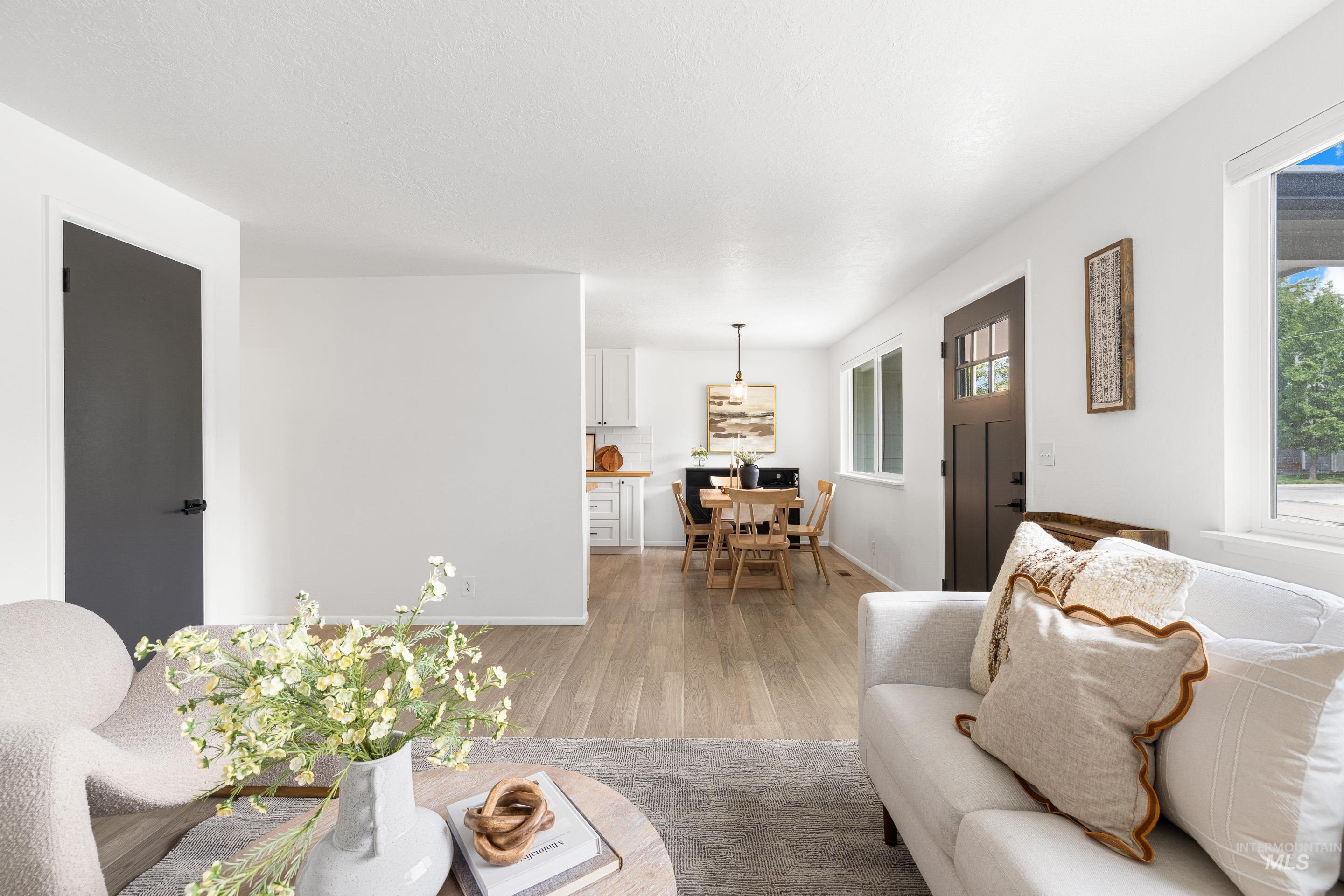 Living room featuring light wood-style flooring and baseboards