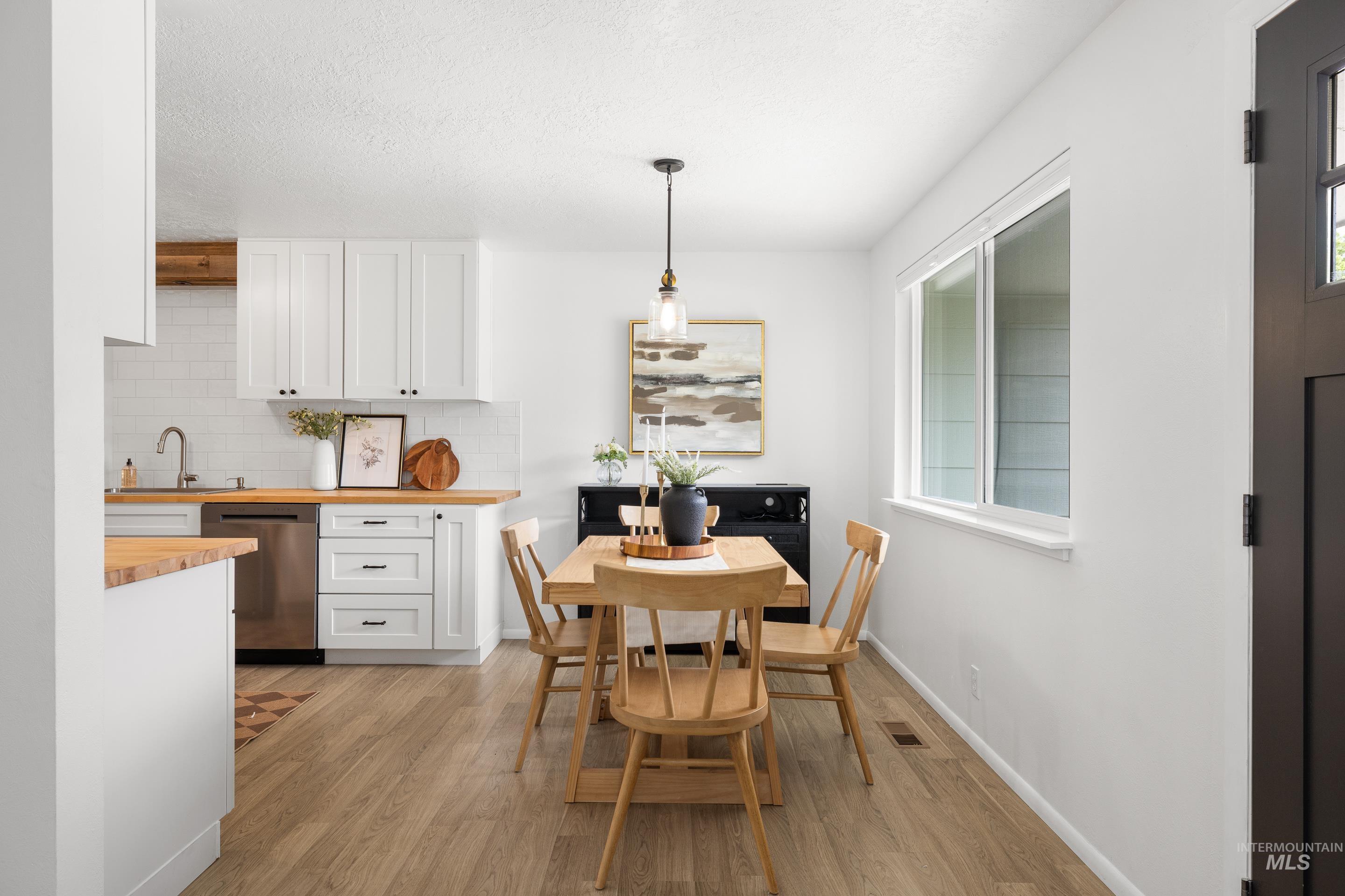 Dining space with light wood-style floors and a textured ceiling
