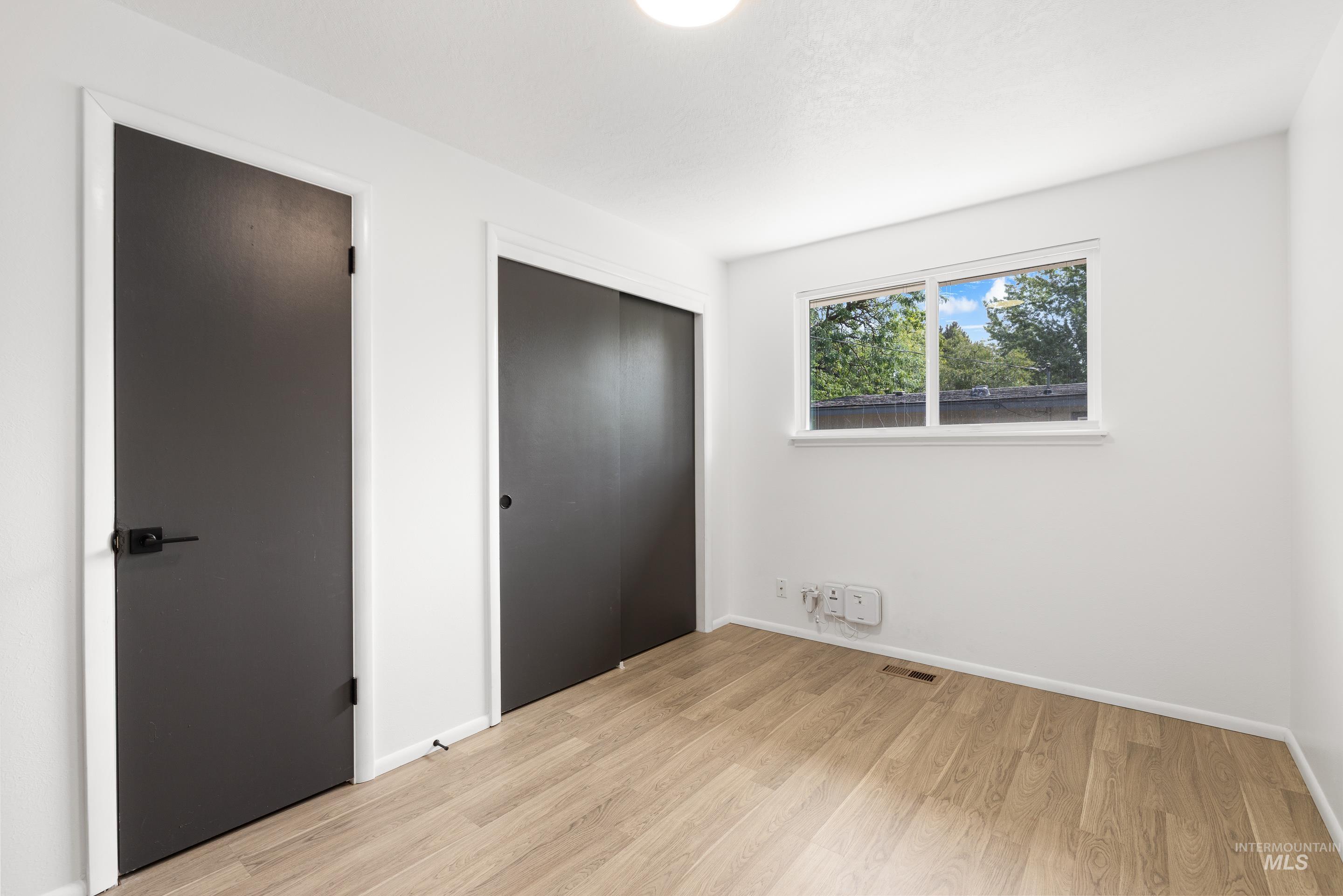 Unfurnished bedroom with light wood-type flooring and a closet