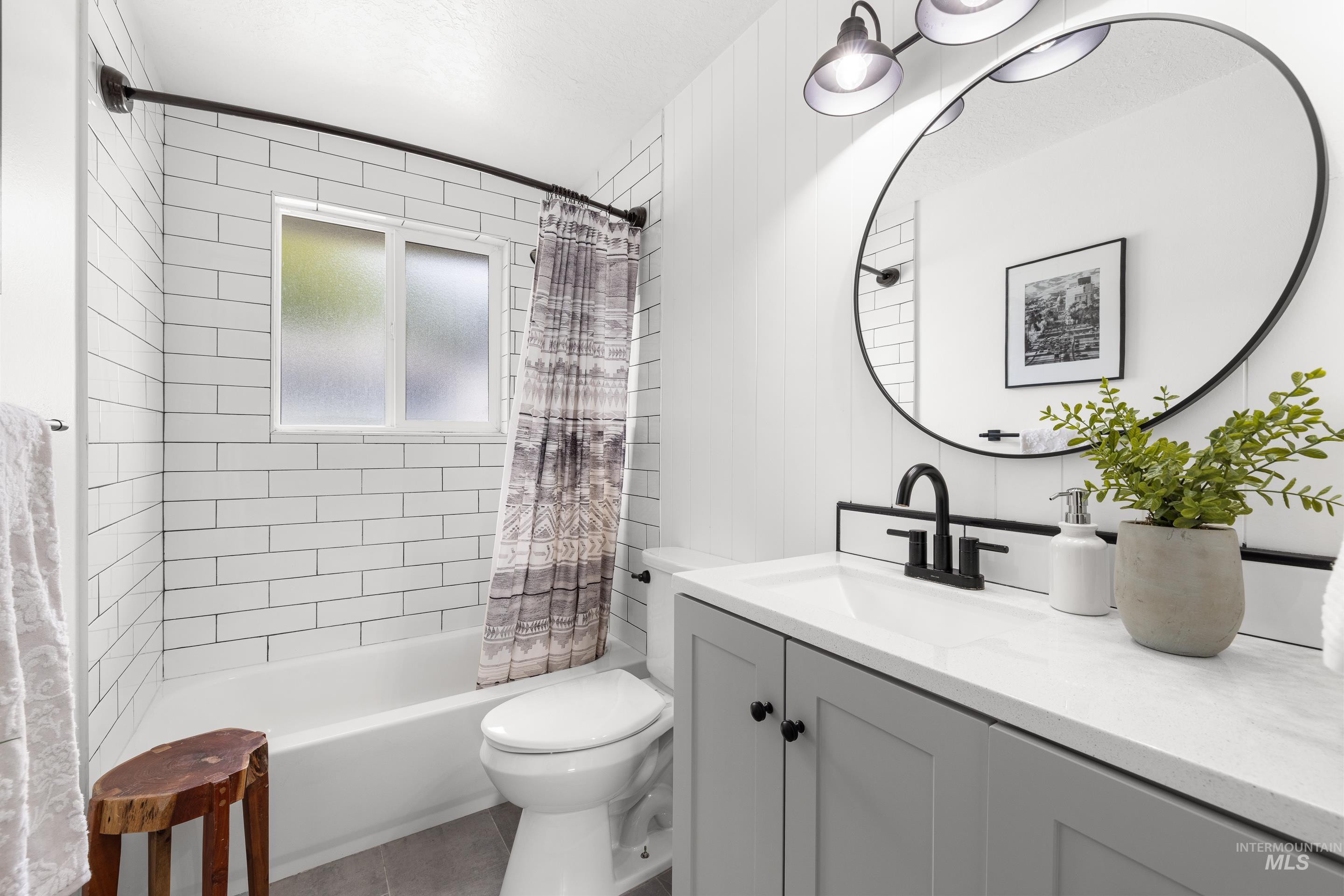Full bathroom featuring shower / tub combo with curtain, vanity, and tile patterned flooring