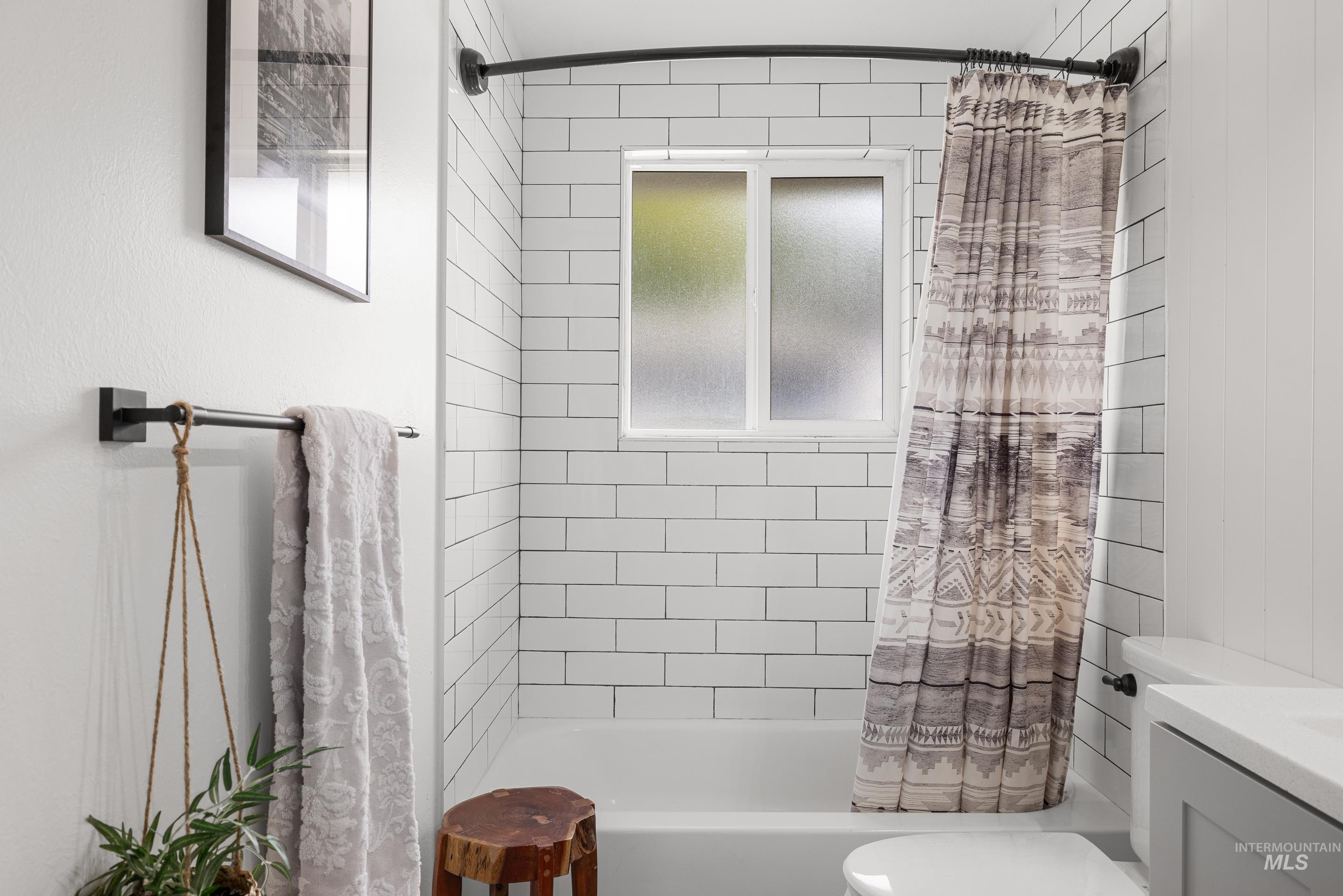 Bathroom featuring shower / bathtub combination with curtain and vanity