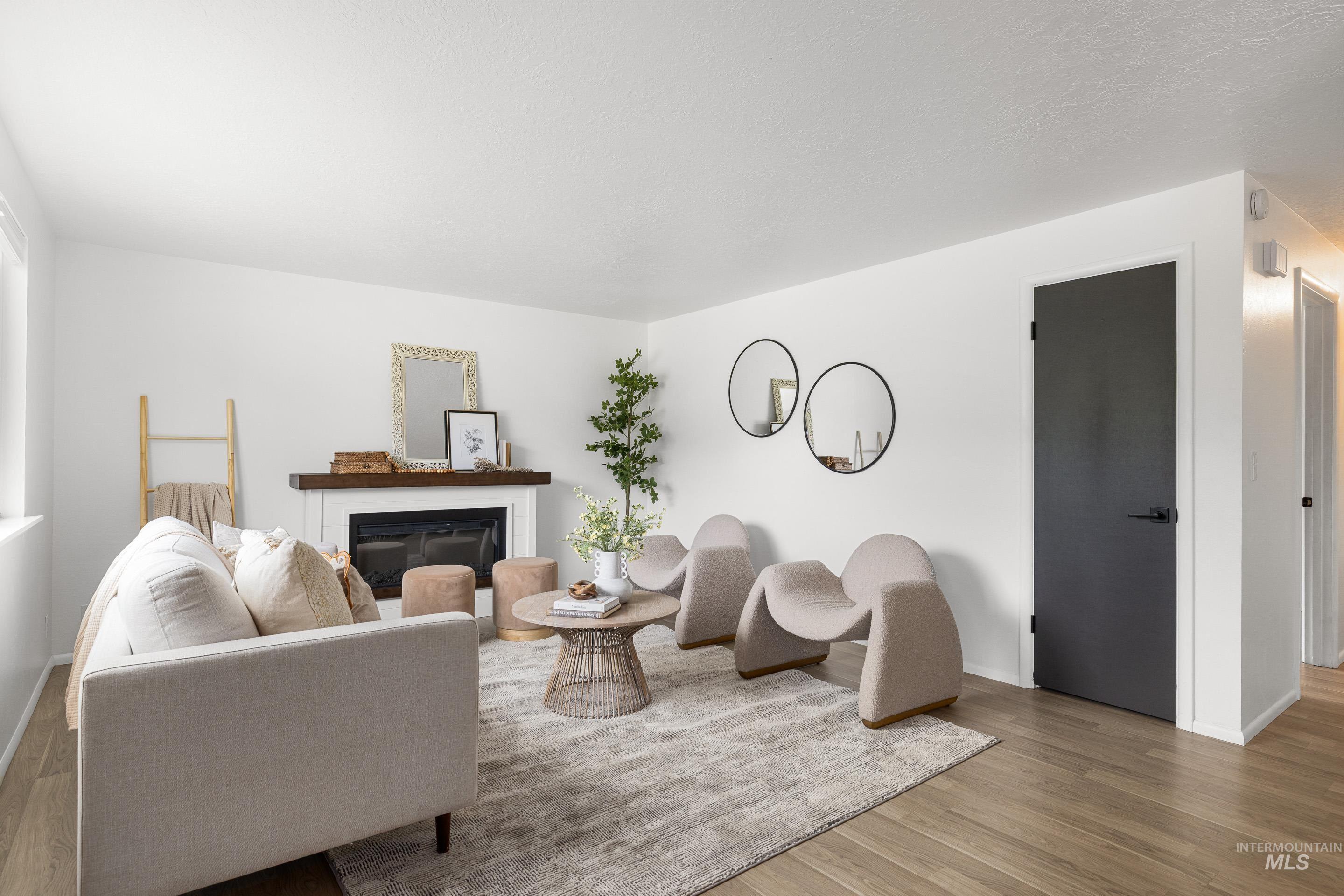 Living area featuring wood finished floors and a glass covered fireplace