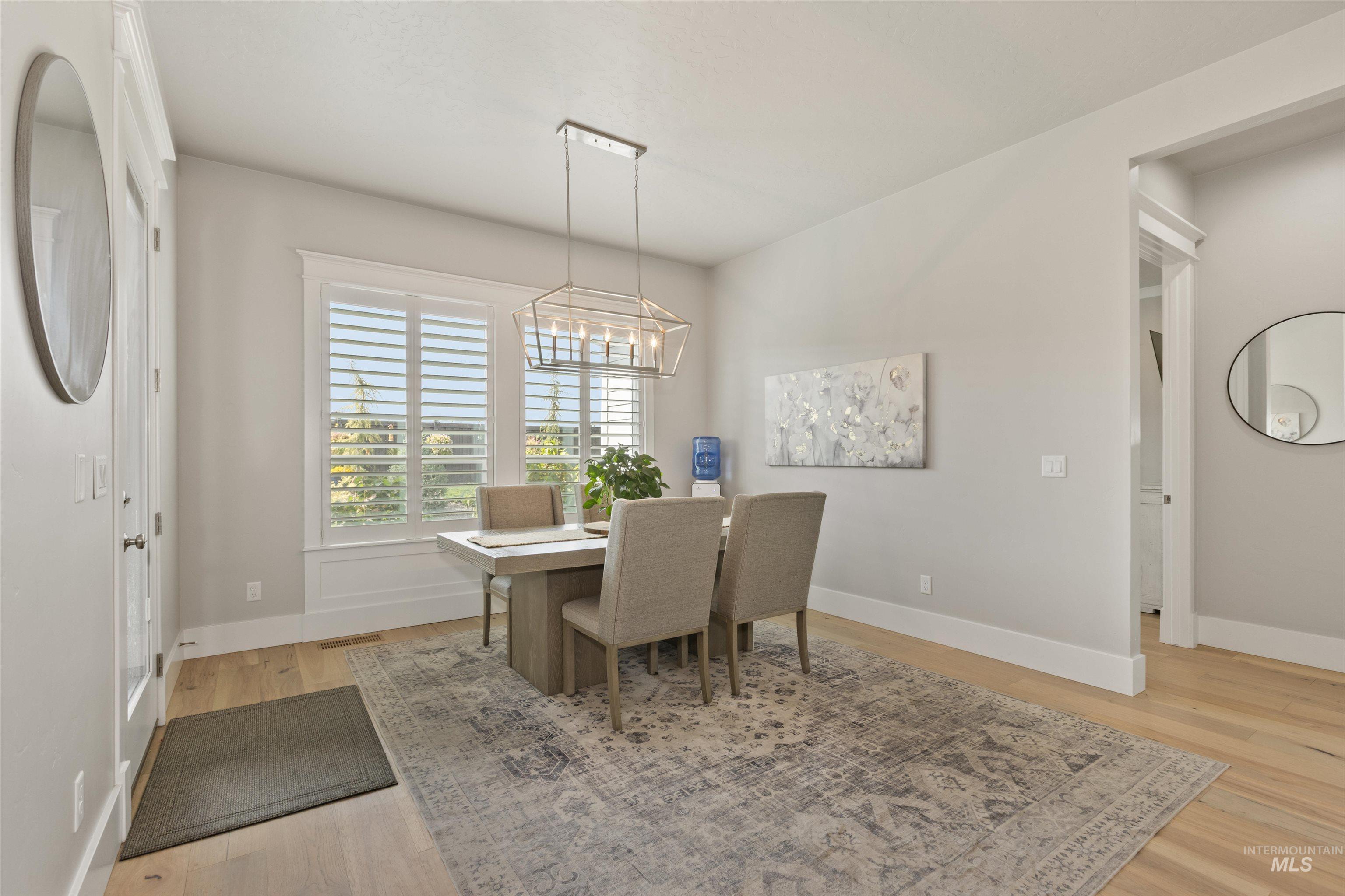 Dining space with light wood-type flooring and a chandelier