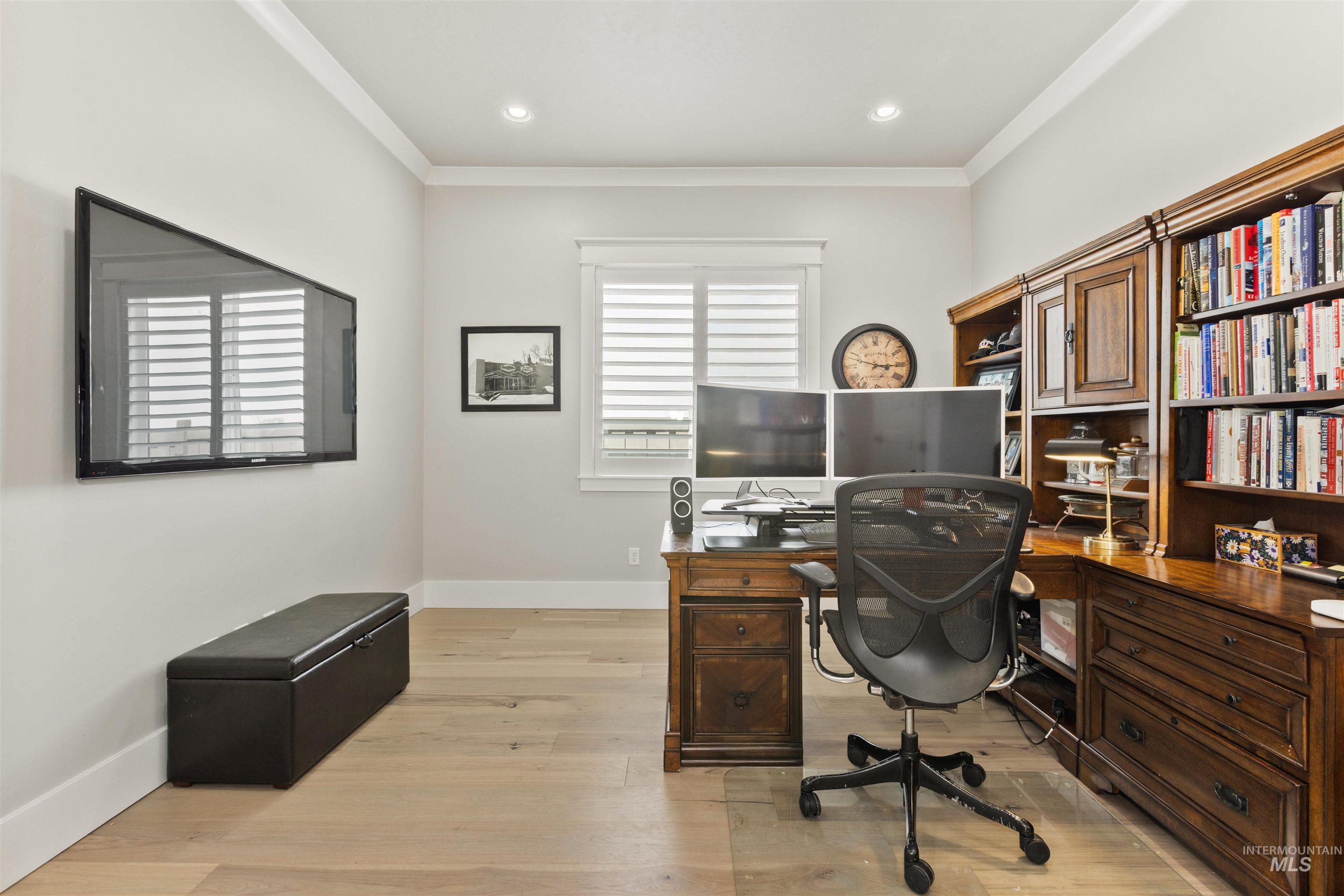 Office space with light wood-style flooring, ornamental molding, and recessed lighting